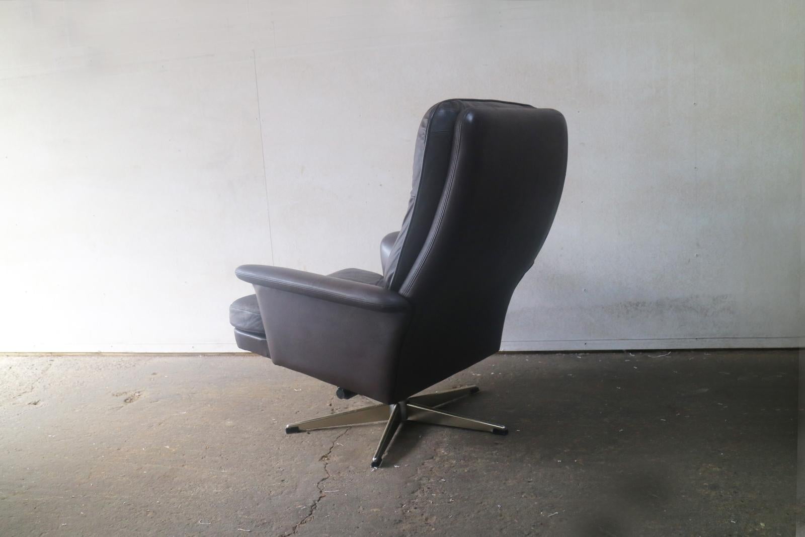 A Danish Mid-Century Modern swivel armchair, with button detailing on seat and back rest, upholstered in the original very dark brown leather.

 
