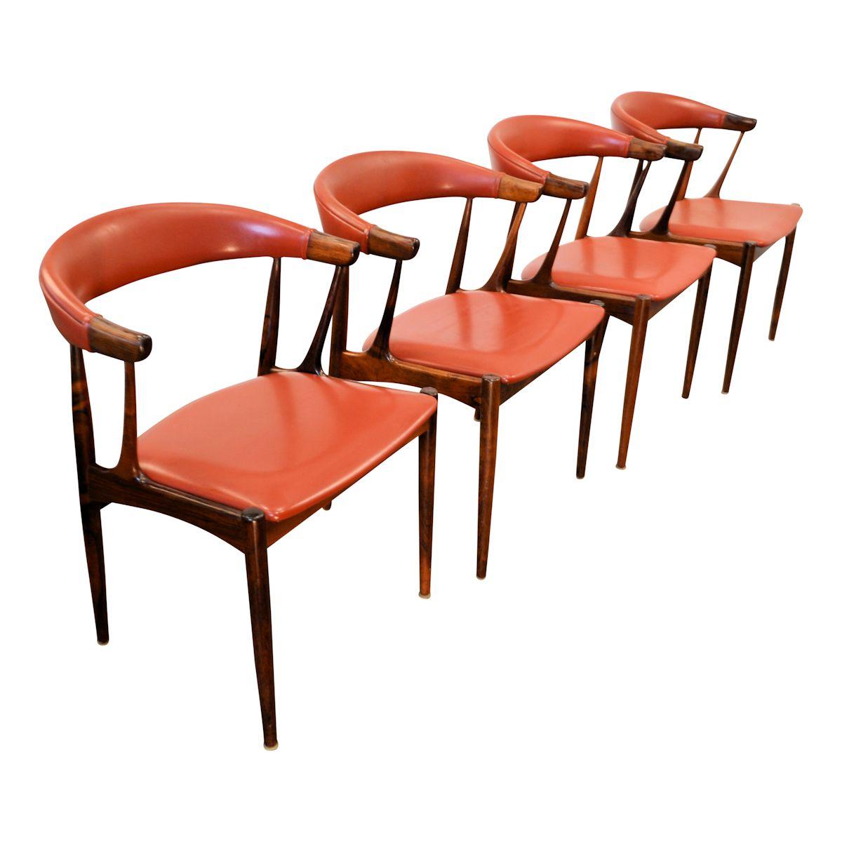 Set of four Danish design palisander armrest chairs, designed by Johannes Andersen for Andersen Møbelfabrik AS in Denmark during the 60's. The chairs have a beautiful shaped palisander frame and a red/brown leatherette upholstery. One chair has some