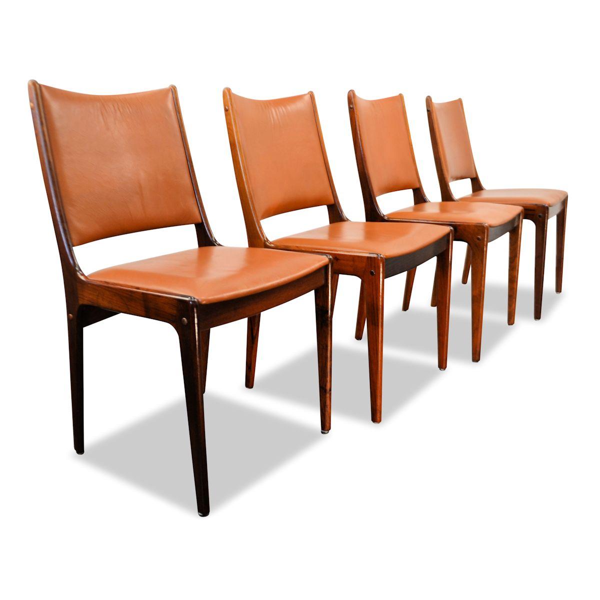 Set of four Danish design palisander dining chairs designed by Johannes Andersen for Uldum Møbelfabrik in Denmark during the 60's. The chairs all have beautiful palisander frames and they all have a cognac color leather upholstery. Some craquelé on
