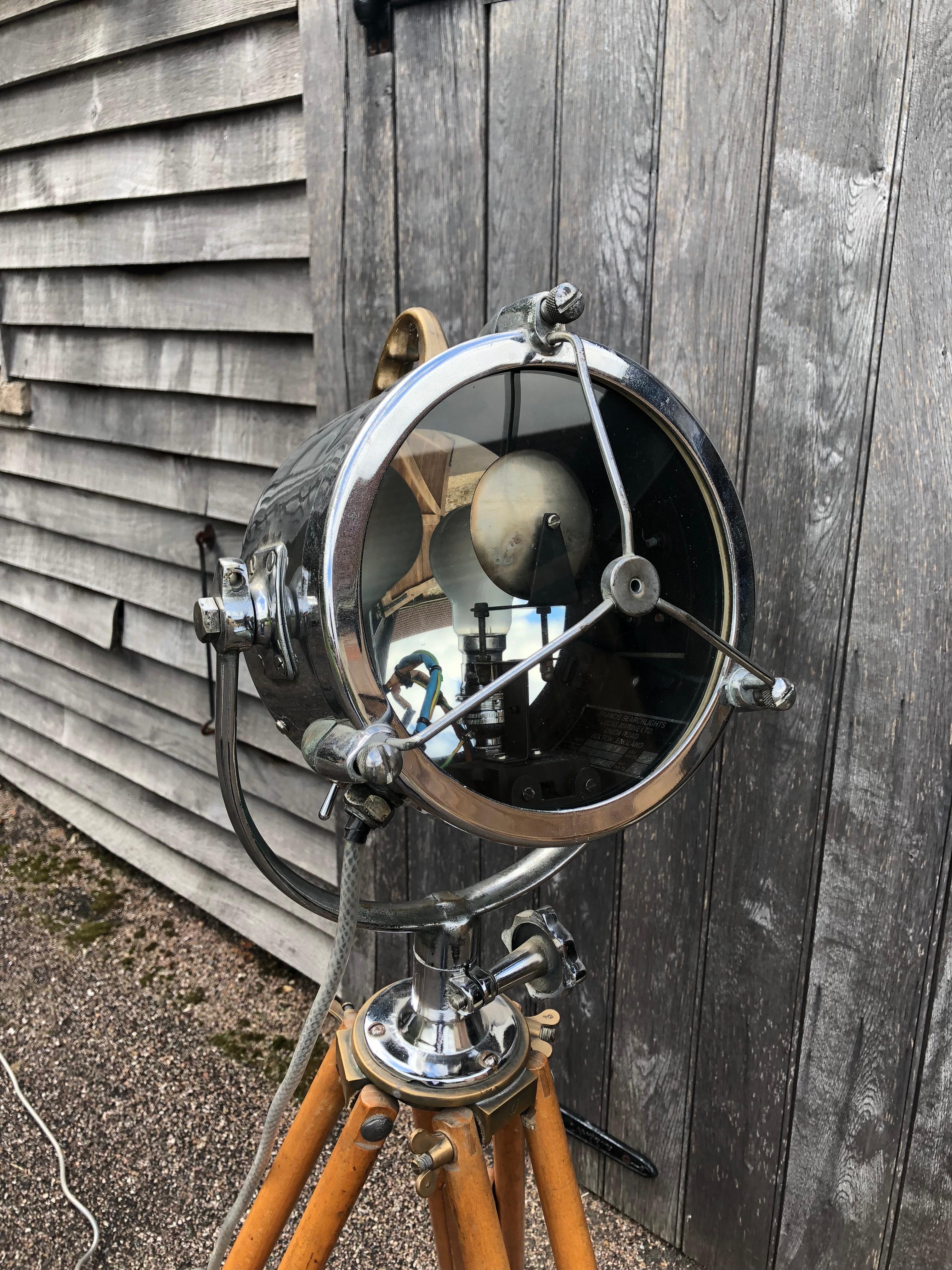 An antique chrome searchlight on a wooden tripod circa 1930. In good antique condition, polished, re-wired, PAT tested and beautifully finished. The tripod is adjustable and has a triangular frame for safety, but this can be removed. Made by Francis
