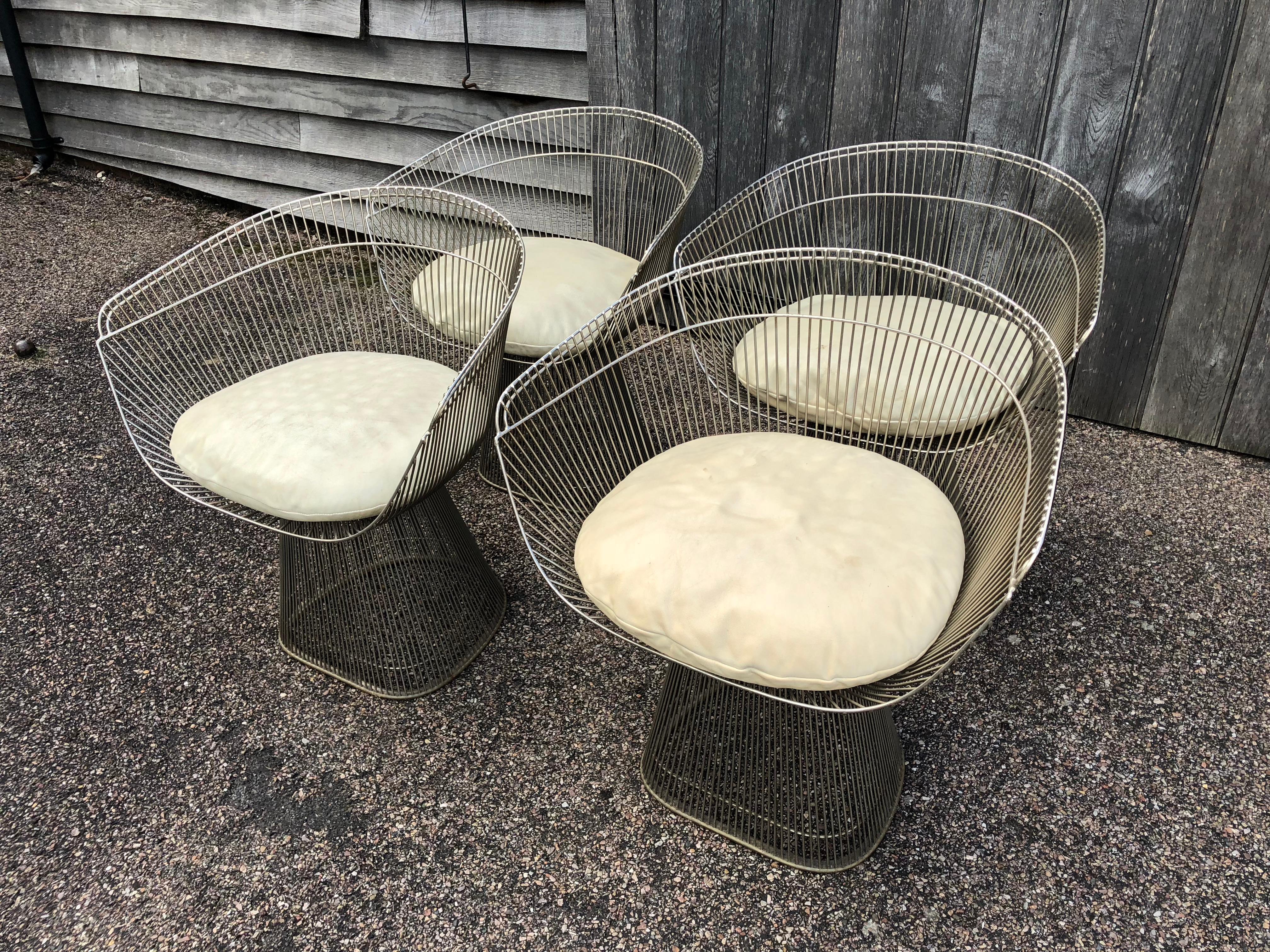 They are original Warren Platner wire-frame lounge or dining chairs manufactured by Knoll, circa 1970.
Complete with original leather seat pads, which are in good used condition. 
Measures: Height 74cm
Width 67cm
Depth 51cm.
 