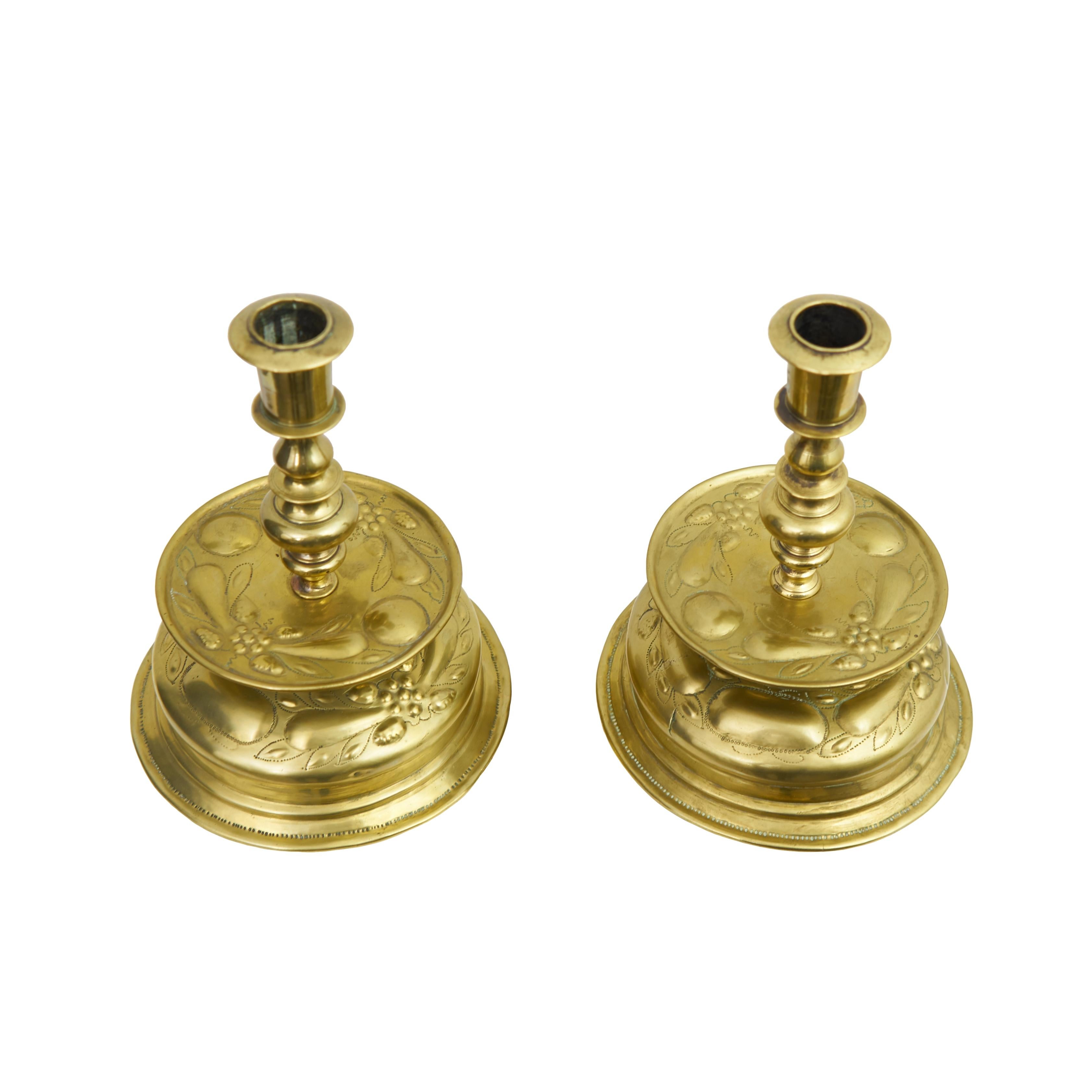 A matched pair of Dome base bell brass candlesticks. These rare Scandinavian candlesticks are 100% original, hand-driven and made of brass, decorated with flowers and grape motifs.
   