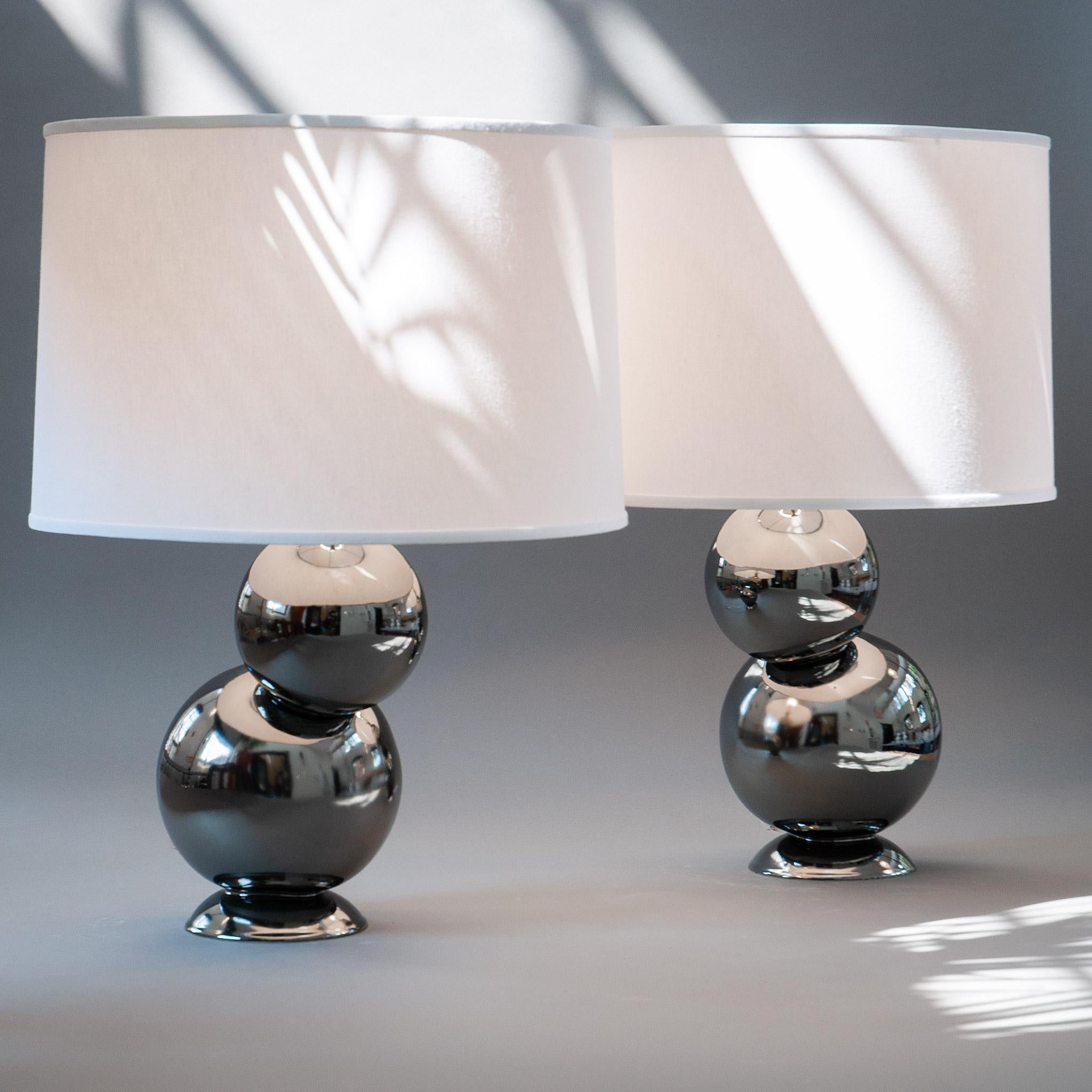 Our homage to Space Age design, the platinum bubble table lamp pair in stoneware is divine whether bookending a credenza or topping off nightstands. Assembled by hand from stoneware orbs that are placed offset from their base, and finished with a