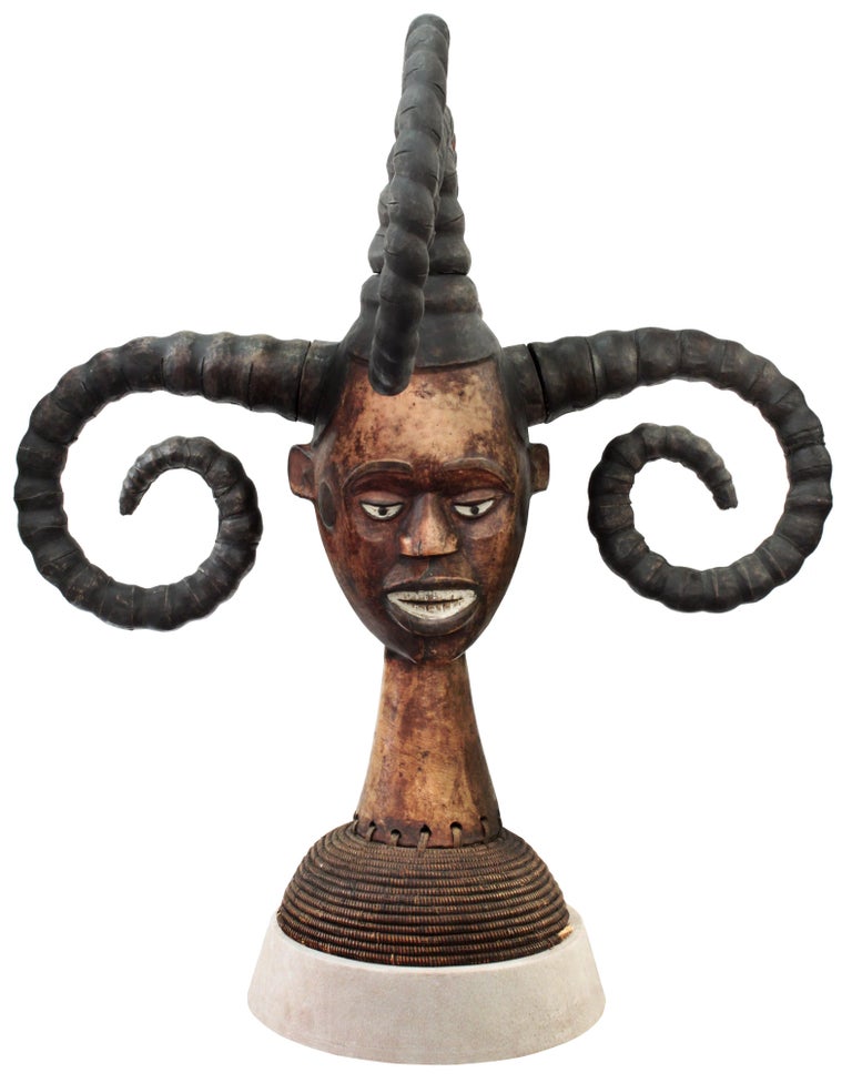 Hand-carved African sculpture, woman's head with four horns, by the Ekoi tribe in Nigeria with a suede base by Karl Springer, American, 1980s (photo of original Karl Springer tag included). The horns are representations of ethnic hair styling. Karl