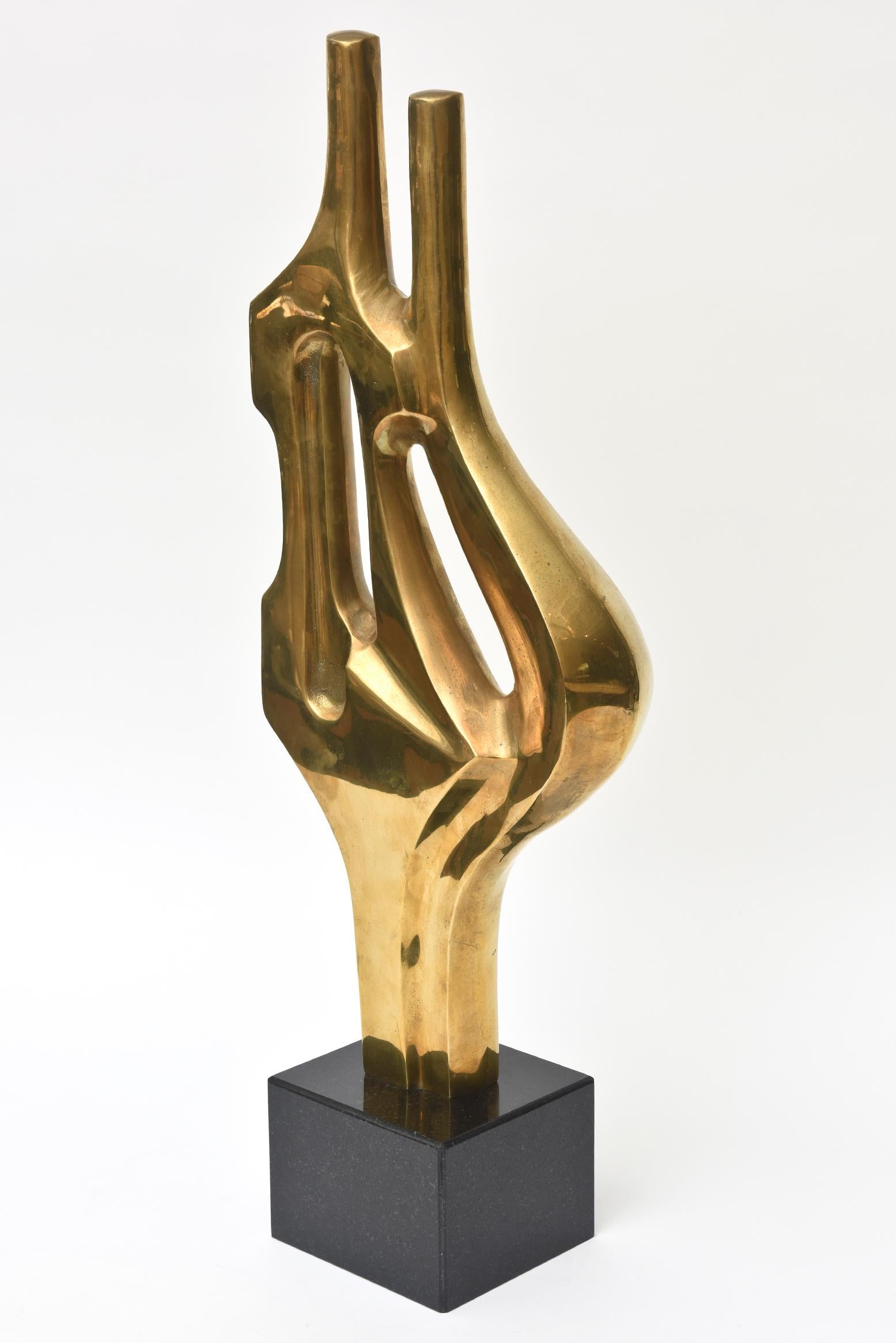 This monumental and fabulous brass and black granite vintage abstract modernist figural sculpture is unsigned. It is period and from the 1970s. It is of two abstract figures connected. It is sophisticated and well executed, it definitely goes the