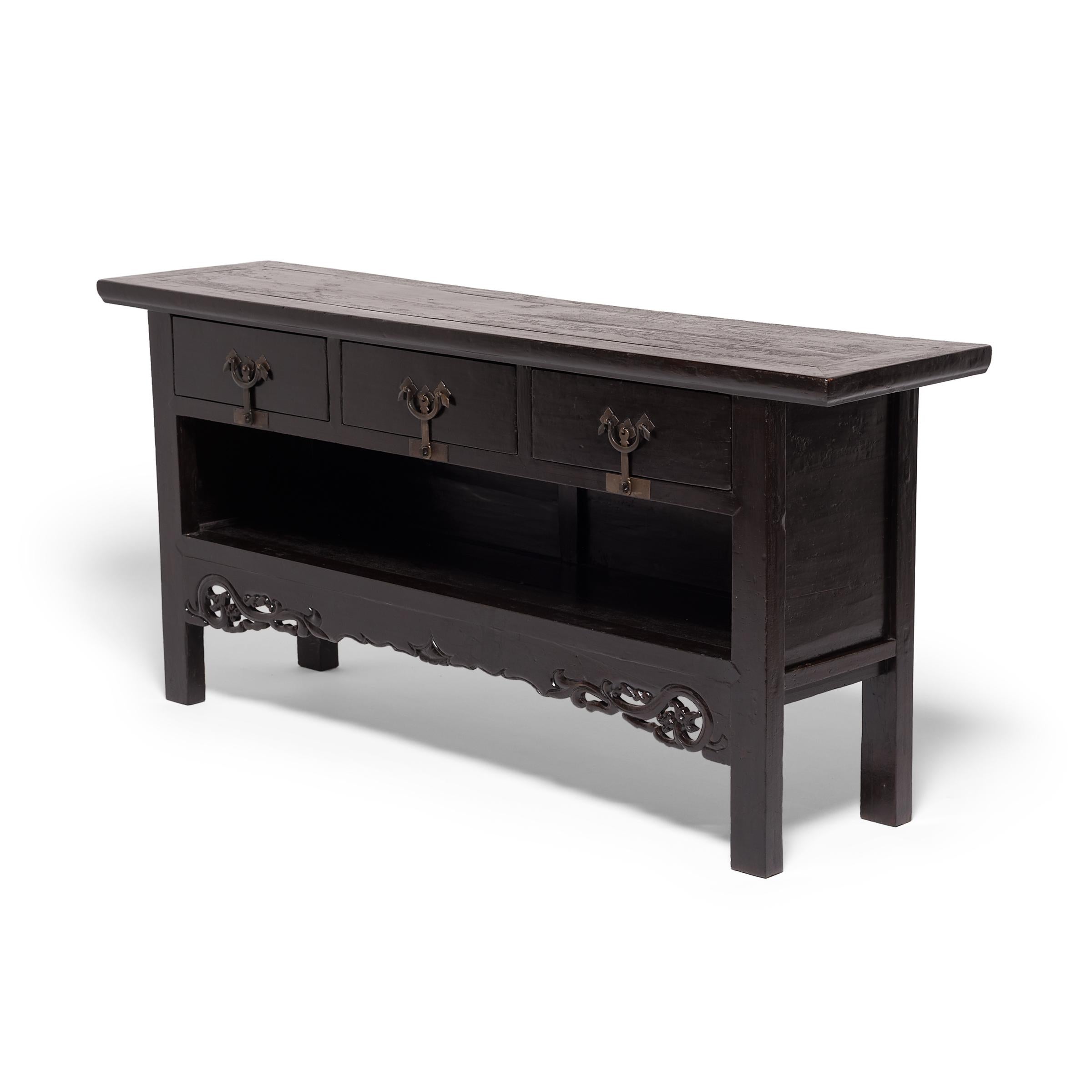 The sleek design of this 19th century three drawer coffer with an open shelf reflects the great tradition of classic Chinese furniture. Handcrafted of elmwood in China’s Henan province, the cabinet's impressive workmanship is evident in its balanced