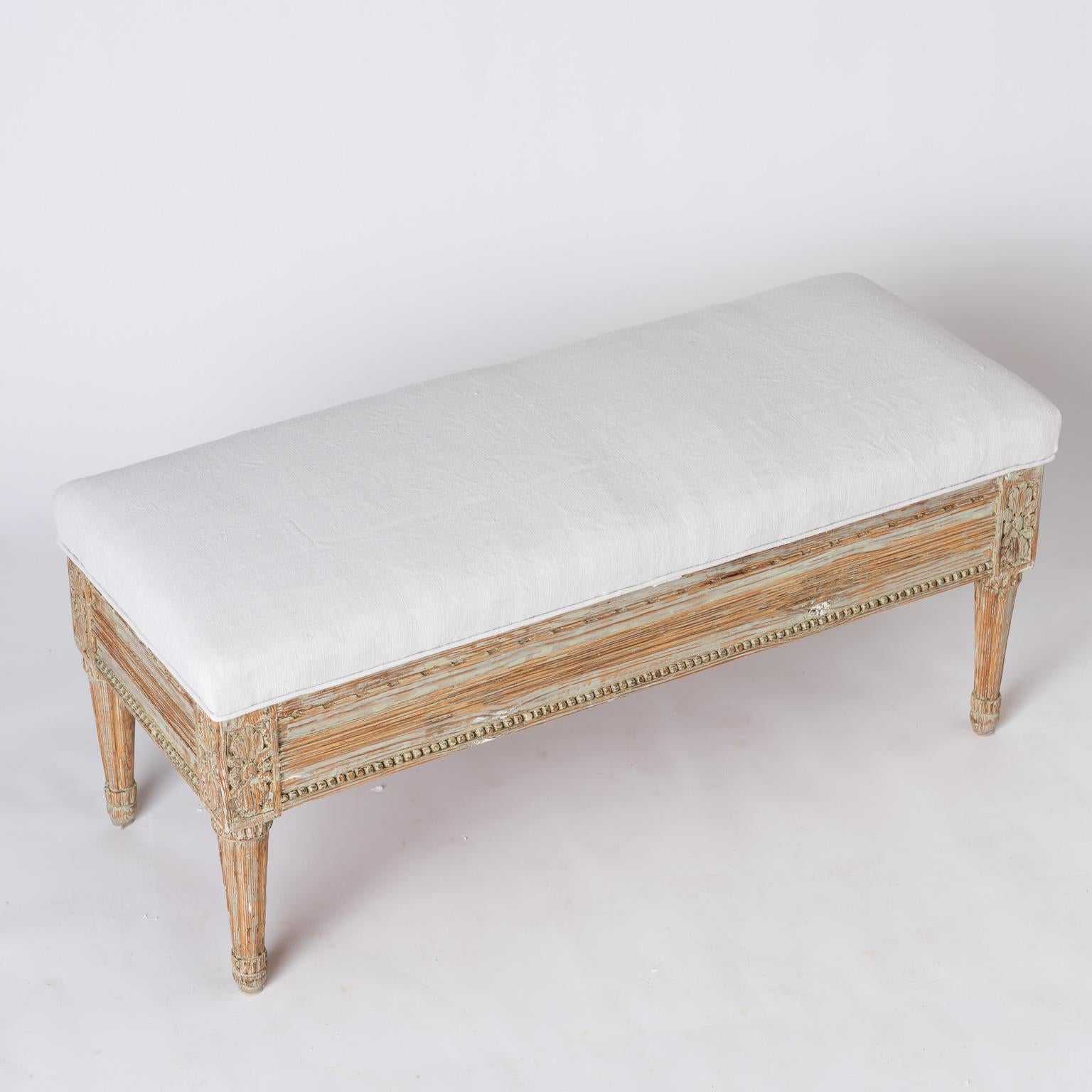 This useful and charming bench has detailed carvings with flowers on the front sides, and nicely tapered legs. The top opens to reveal plenty of storage, and beautiful old iron hinges. The paint surface is original. This piece could also be used as