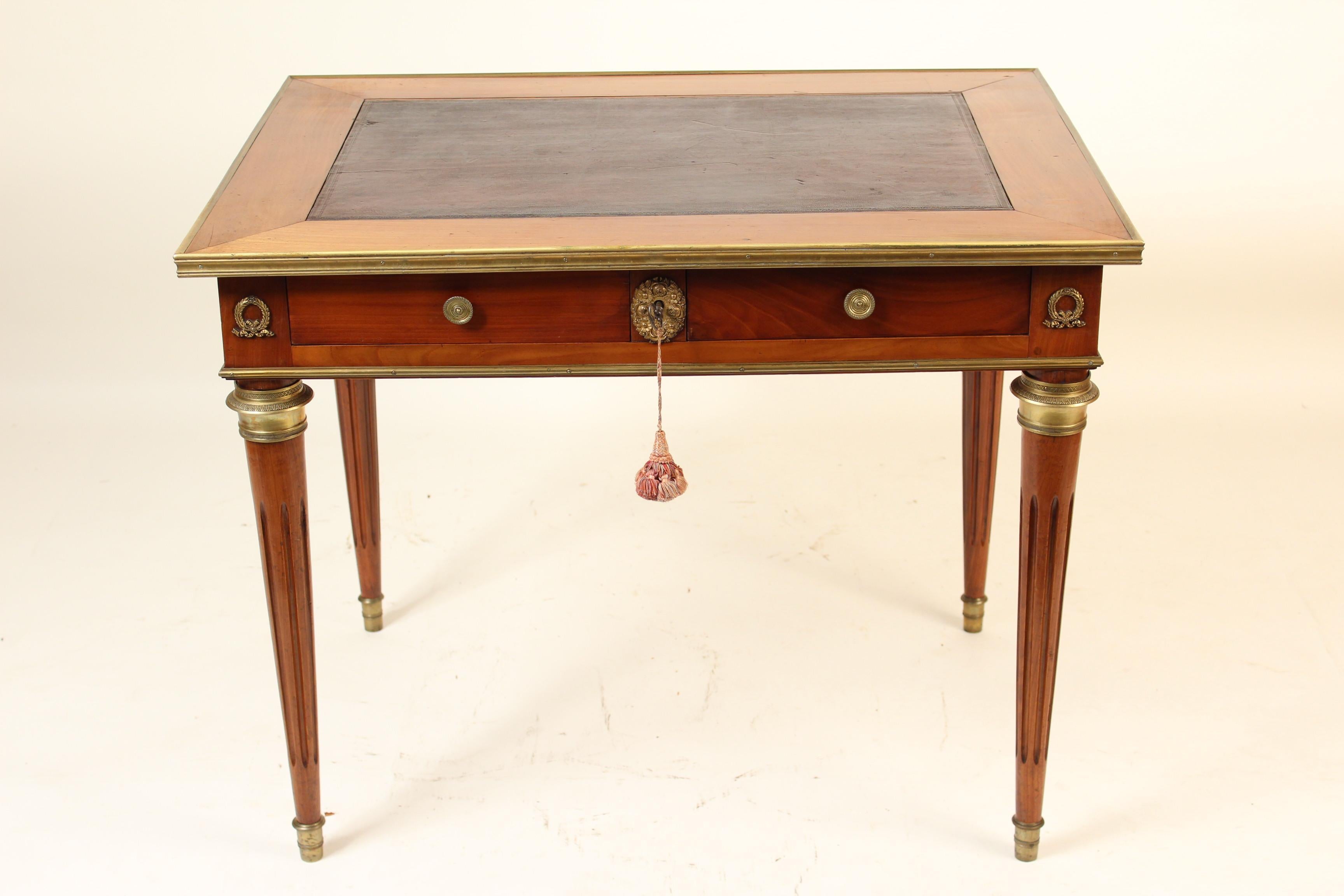 Louis XVI style beechwood partners writing table / desk with bronze mounts and a leather top, circa 1930's. This writing table has excellent quality bronze mounts reflecting it's fine quality craftsmanship. The drawers open on either side of the