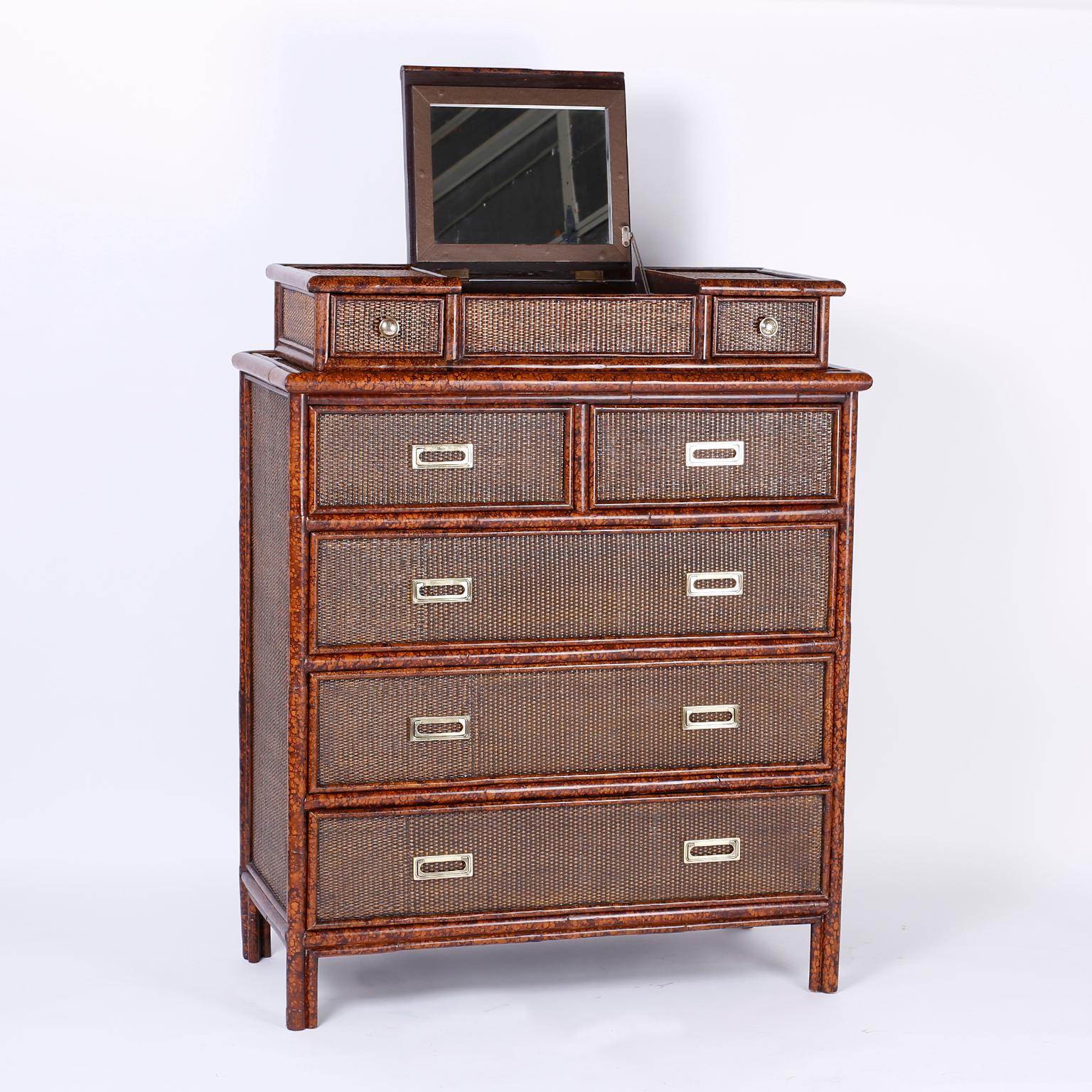 Midcentury British Colonial style chest of drawers with an unusual removable vanity top and fold out mirror. Having an intriguing faux tortoise frame over a grass cloth case and campaign style hardware.

Measures: Height without vanity 43