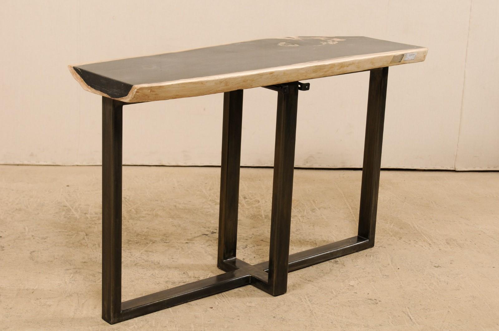 A petrified wood top modernly designed console table. This custom console table has been fashioned from a single thick slab of smoothly polished petrified wood. This fabulous petrified wood top is mostly black with shades of tan and bone at its