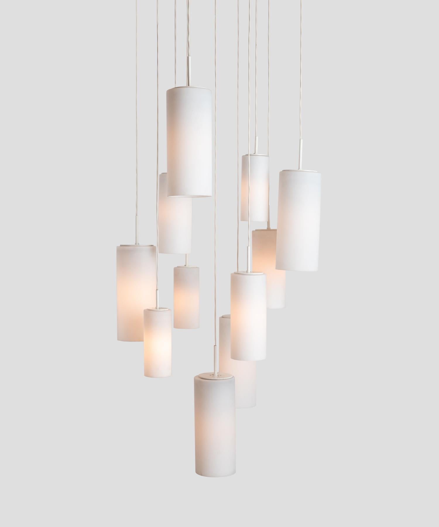 Opaline suspension chandelier by Philips, Netherlands, circa 1960.

Eleven cascading opaline cylindrical shades in various sizes at adjustable heights.