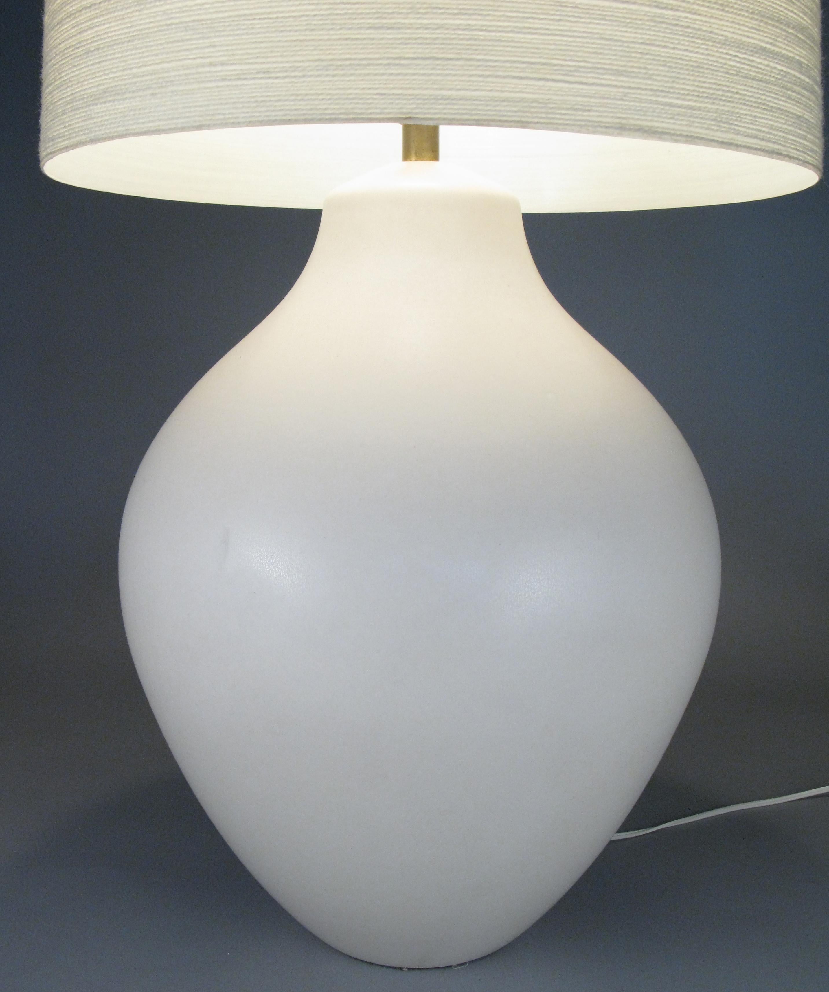 A very nice large 1960s ivory colored Danish ceramic lamp with its original jute wrapped shade. this is an unusual large size and form. Classic and charming, and the shade casts a warm glow.