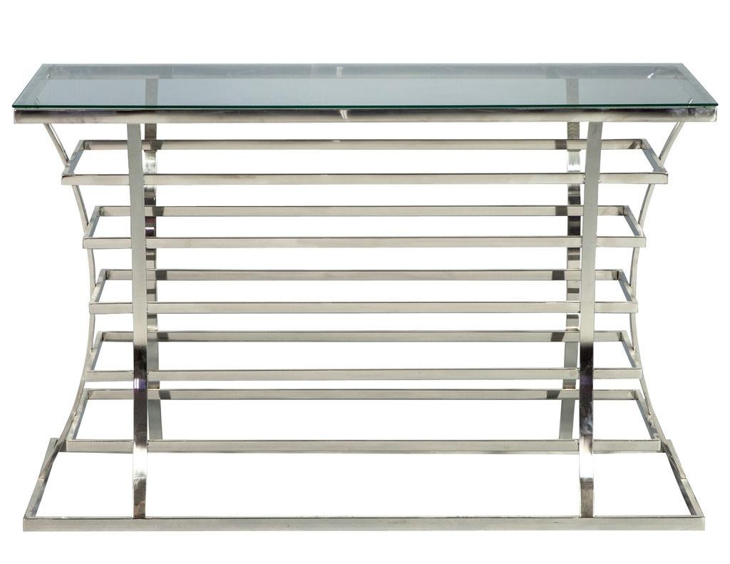 Jack Fhillips stainless steel and glass console table. Created by Jack Fhillips this console features stainless steel created with a spiral designed body and a curved flowing shape that adds to the dimension of floating rectangles. The perfect piece