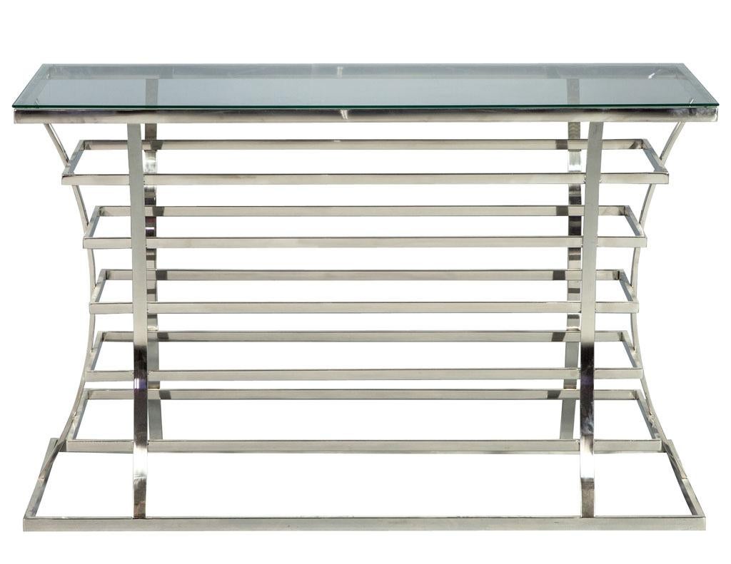 Consola de acero inoxidable y cristal Jack Fhillips. Creada por Jack Fhillips, esta consola presenta acero inoxidable creado con un cuerpo diseñado en espiral y una forma curva fluida que añade dimensión a los rectángulos flotantes. La pieza