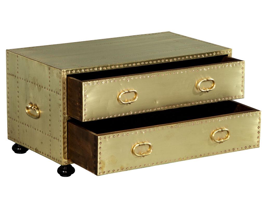 This vintage 1970s brass cladded chest of drawers features a patterned brass nail head design. It has two solid drawers for great storage and sits atop four simple feet. Its wear is consistent with its age and with this provides an exclusive and one