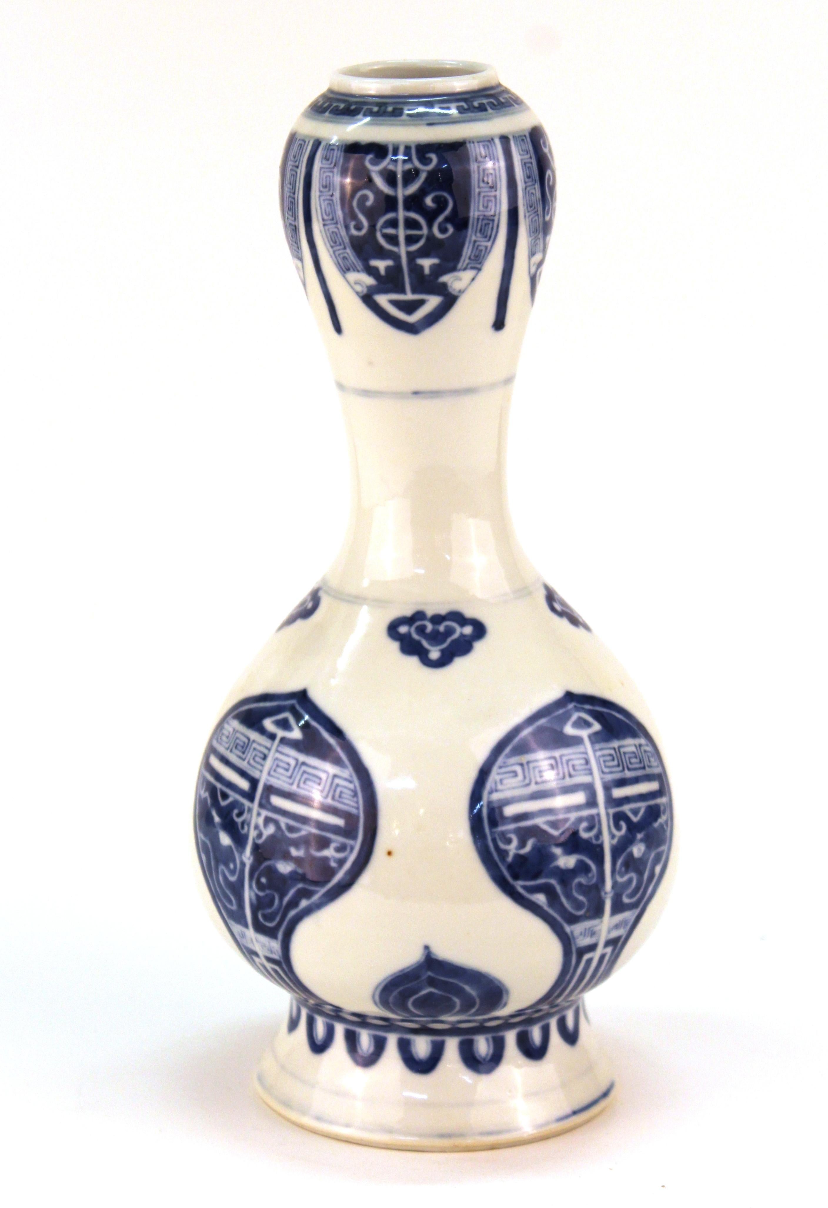 Chinese antique suantouping or 'garlic head' vase in under-glazed blue and white porcelain, created in China during the Kangxi style and dating from the later 19th century. The vase has stylized designs on its bulbous surface and marks on the