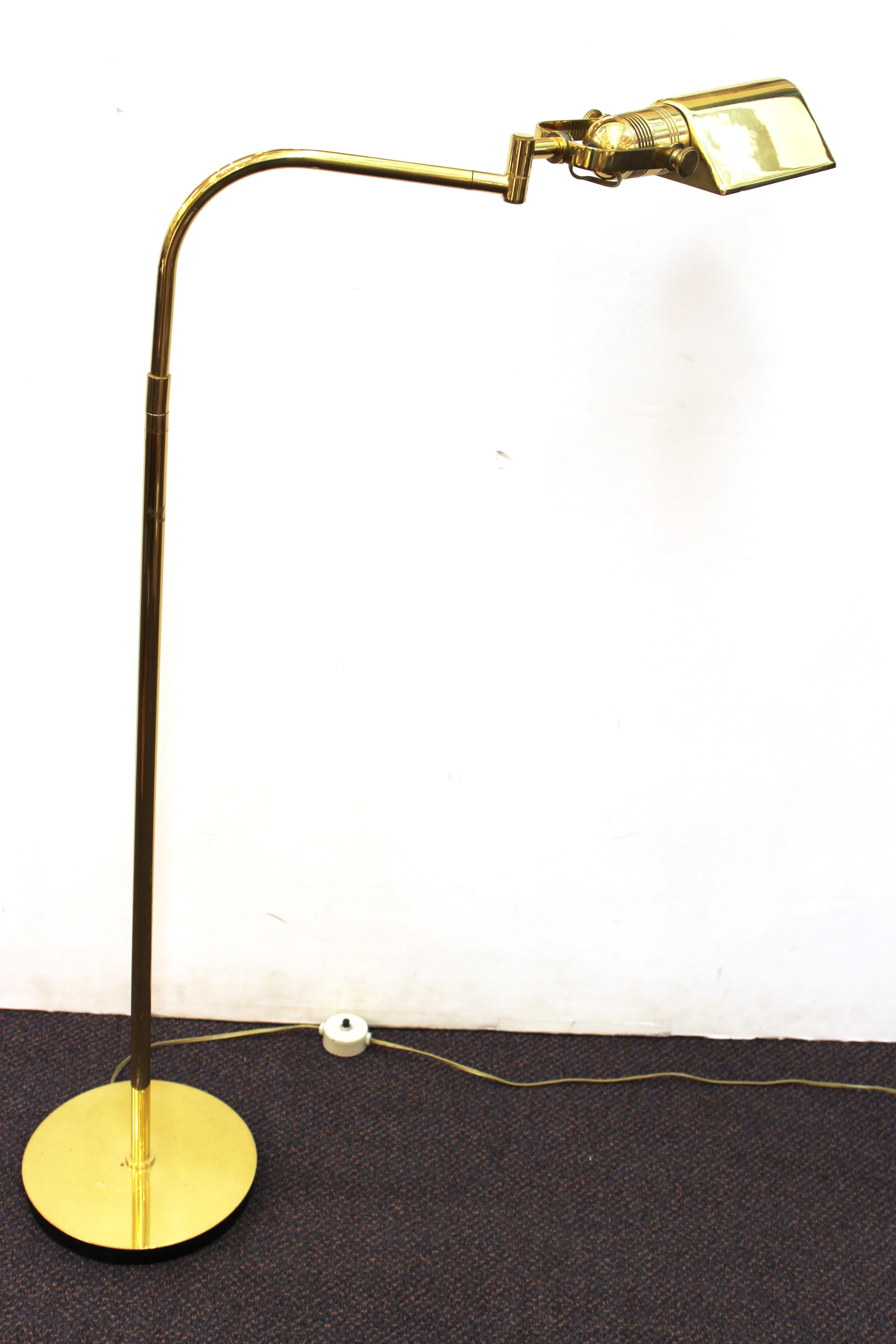 Pair of Mid-Century Modern reading lamps or floor lamps, made in brass by Nessen Studio. The pair has articulated heads and adjustable height and is in great vintage condition with age-appropriate wear to the metal patina.