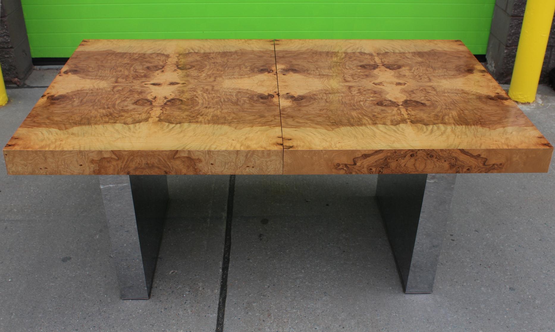 Milo Baughman extendable dining table from the mid-20th century with a burl wood top made out of several slabs oriented to form a pattern with the natural lines of the wood. The table stands on a pair of rectangular chrome legs. Comes with two