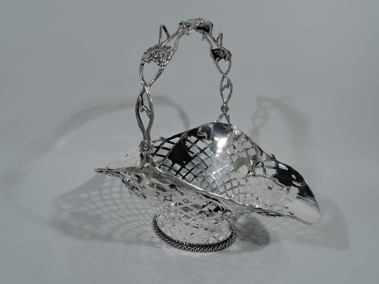 Large and bountiful Art Nouveau sterling silver basket. Made by Mauser in New York. Oval with flared ovoid mouth and c-scroll open swing handle. Open weave sides with vine-form rim fruiting grape bunches applied to sides. Handle same. Hallmarked.