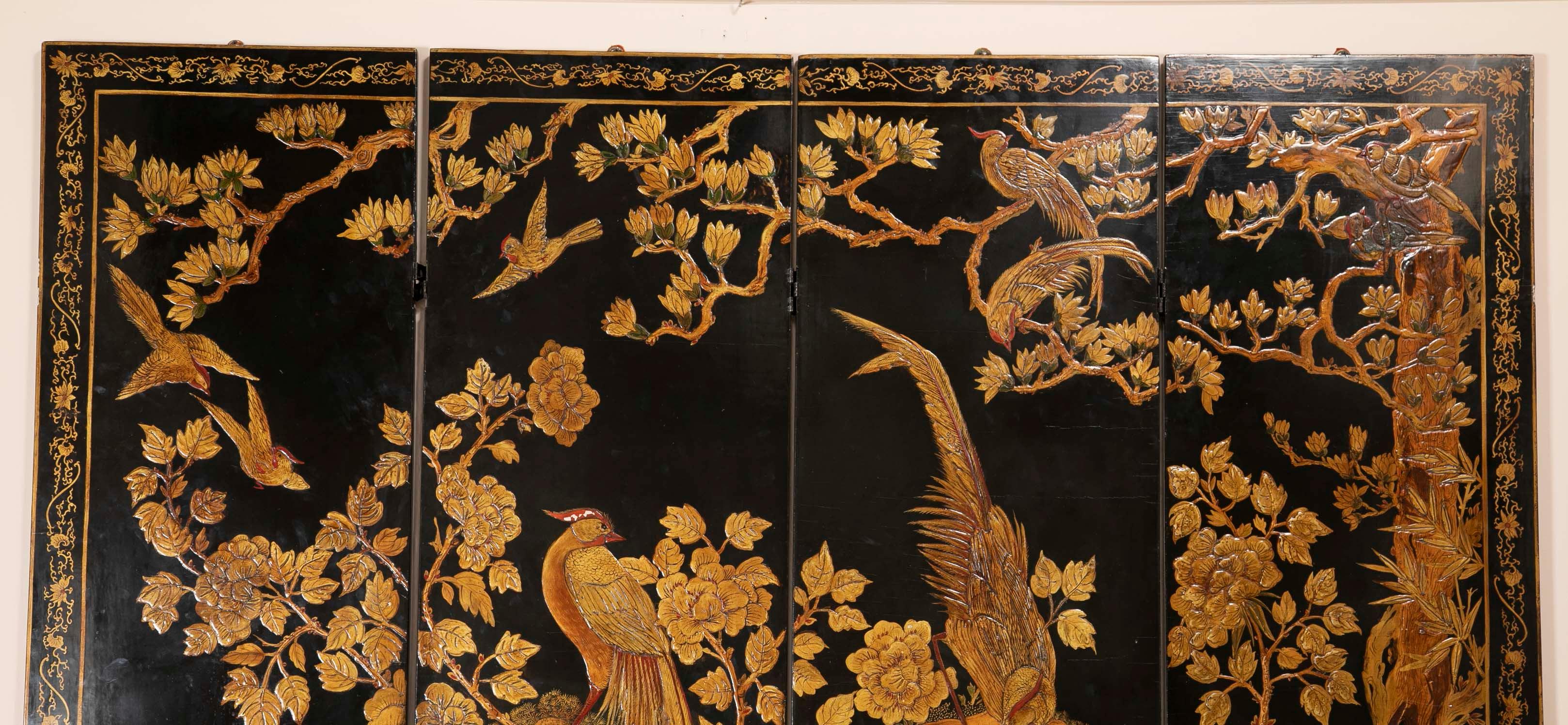 A Coromandel Chinese screen depicting a Phoenix in a wooded scene. Late 19th century.