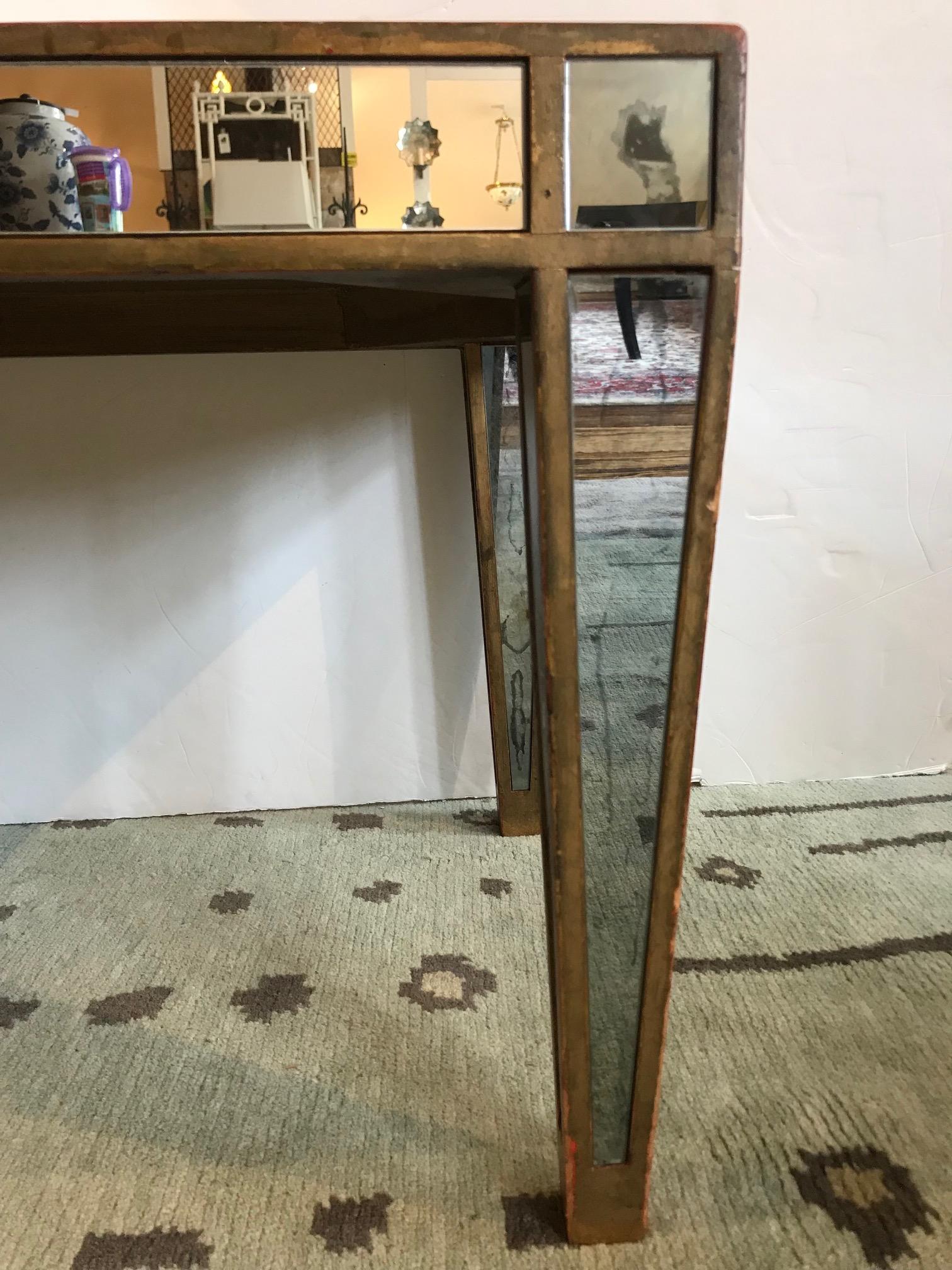 A long rectangular mirrored coffee table having tapered legs and painted bronze wooden structure. One half of one side of mirrored narrow panel is new and one small square on leg has also been replaced. Please note they do not match the rest of the
