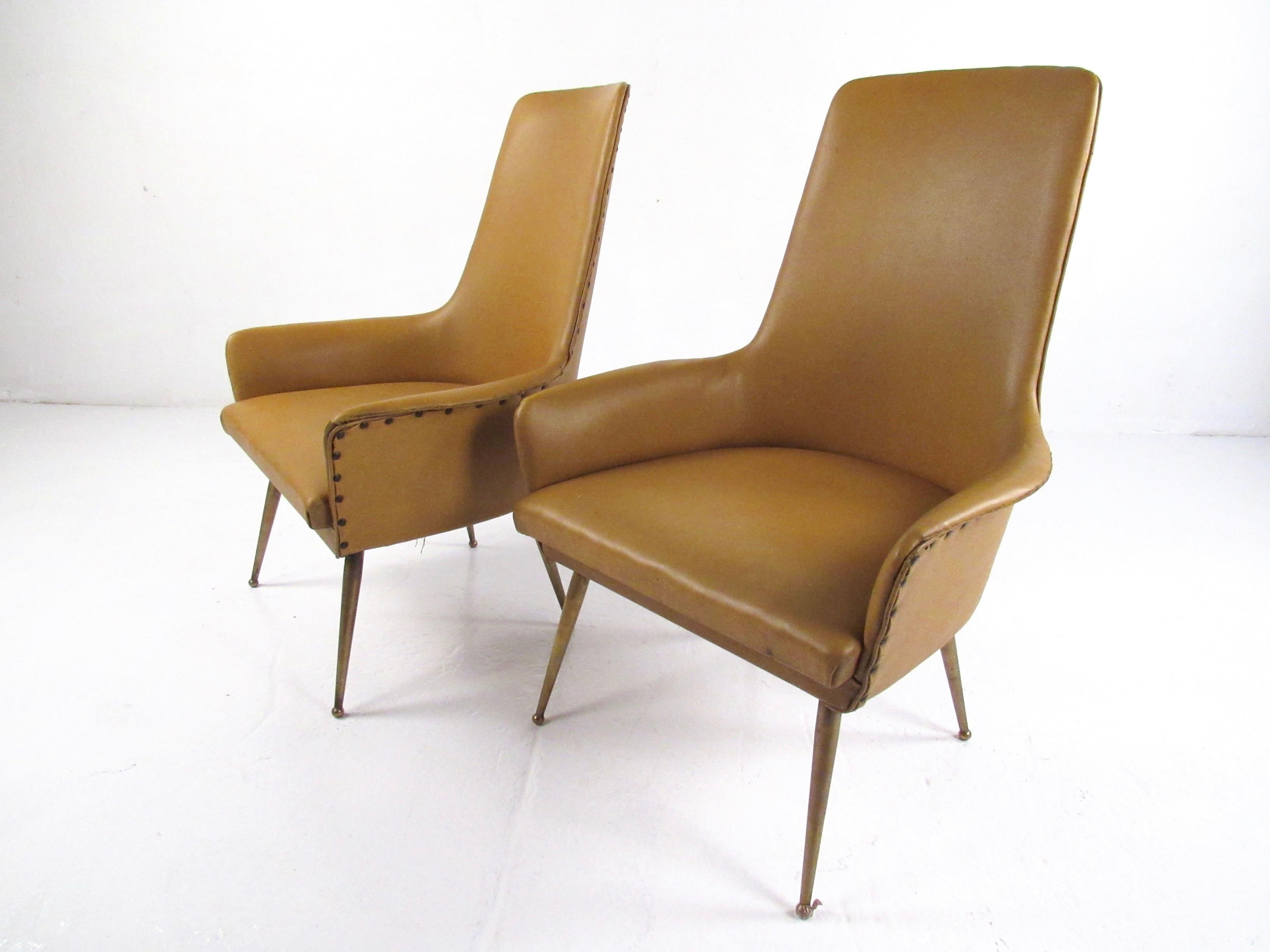 This striking pair of vintage modern side chairs feature exquisite midcentury Italian design including tall sculpted seat backs, low wing-like arms, and tapered brass finish legs. Comfortable and stylish, this matched pair of armchairs make an