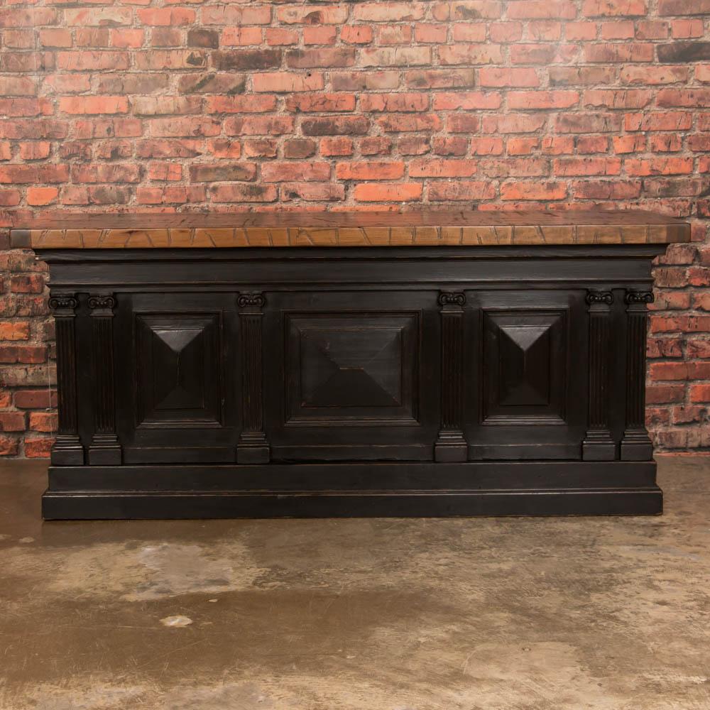 This impressive freestanding island will be the gathering place in any kitchen. This versatile piece was originally a grocer's counter in the 1800s and is finished on all four sides with carved moldings and raised panels, recently painted black to