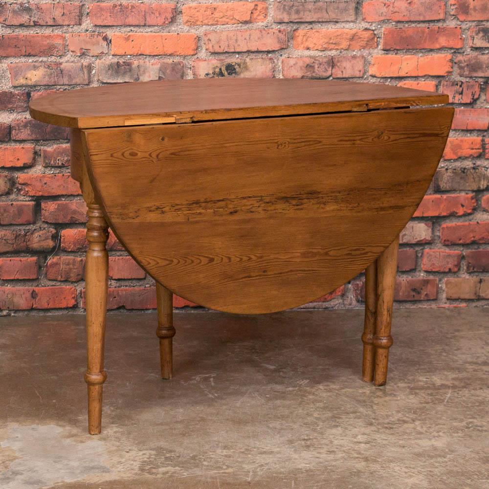 An unusual find, this drop leaf pine game table's country appeal is second only to it's versatility. With the leaf down it makes a wonderful console and when the hidden leg is extended it becomes the perfect game table. It has a wax finish bringing