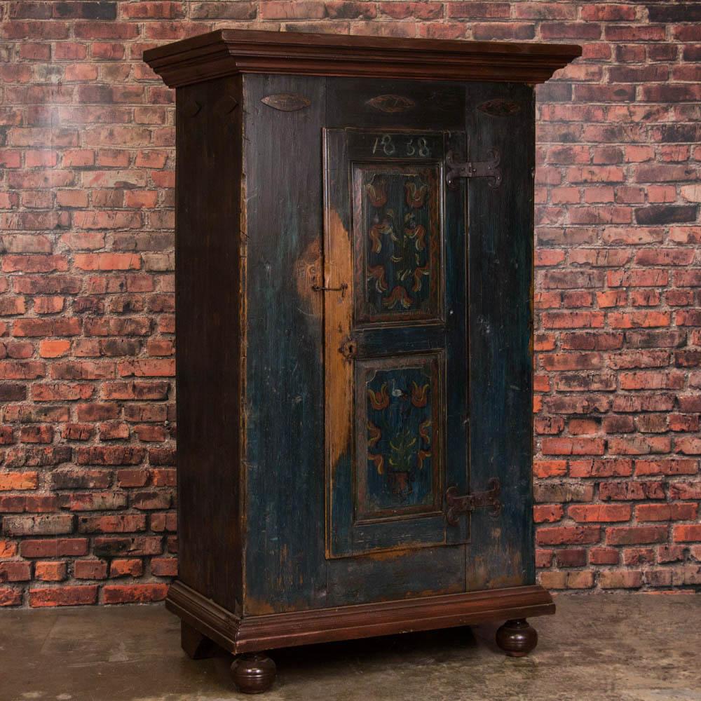 This captivating armoire is a lovely example of Russian country craftsmanship from the mid-1800s. The deep, rich patina of the worn dark blue paint in this pine armoire is due to its age, with a date of 1858. Please enlarge and examine the close up