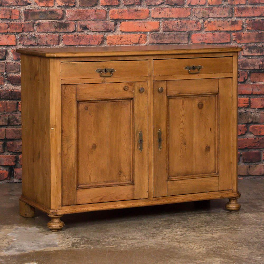 Simple country charm is the hallmark of this pine sideboard, which has the clean lines and styling of a traditional Danish cabinet from the late 1800's. The panel doors each have a knob making them easy to open, revealing ample storage inside. The