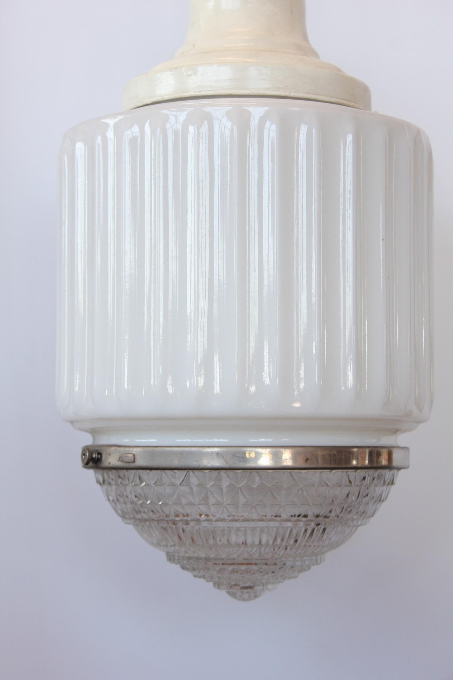 Antique department store milk glass pendant light with patterned glass bottom.