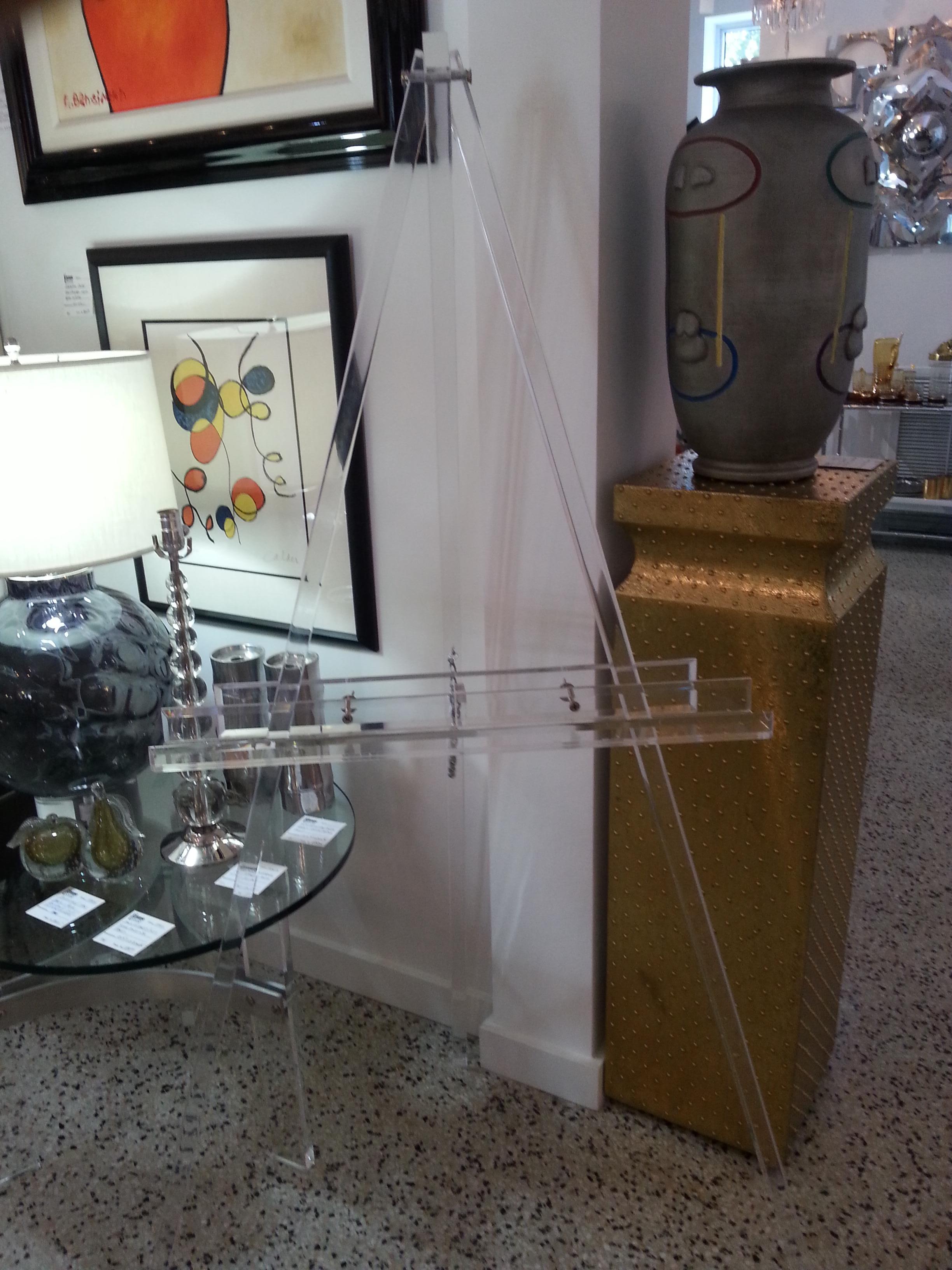 This stylish adjustable Lucite easel is custom made by iconic Snob Galereries.

Note: Dimension of height is 61.50
