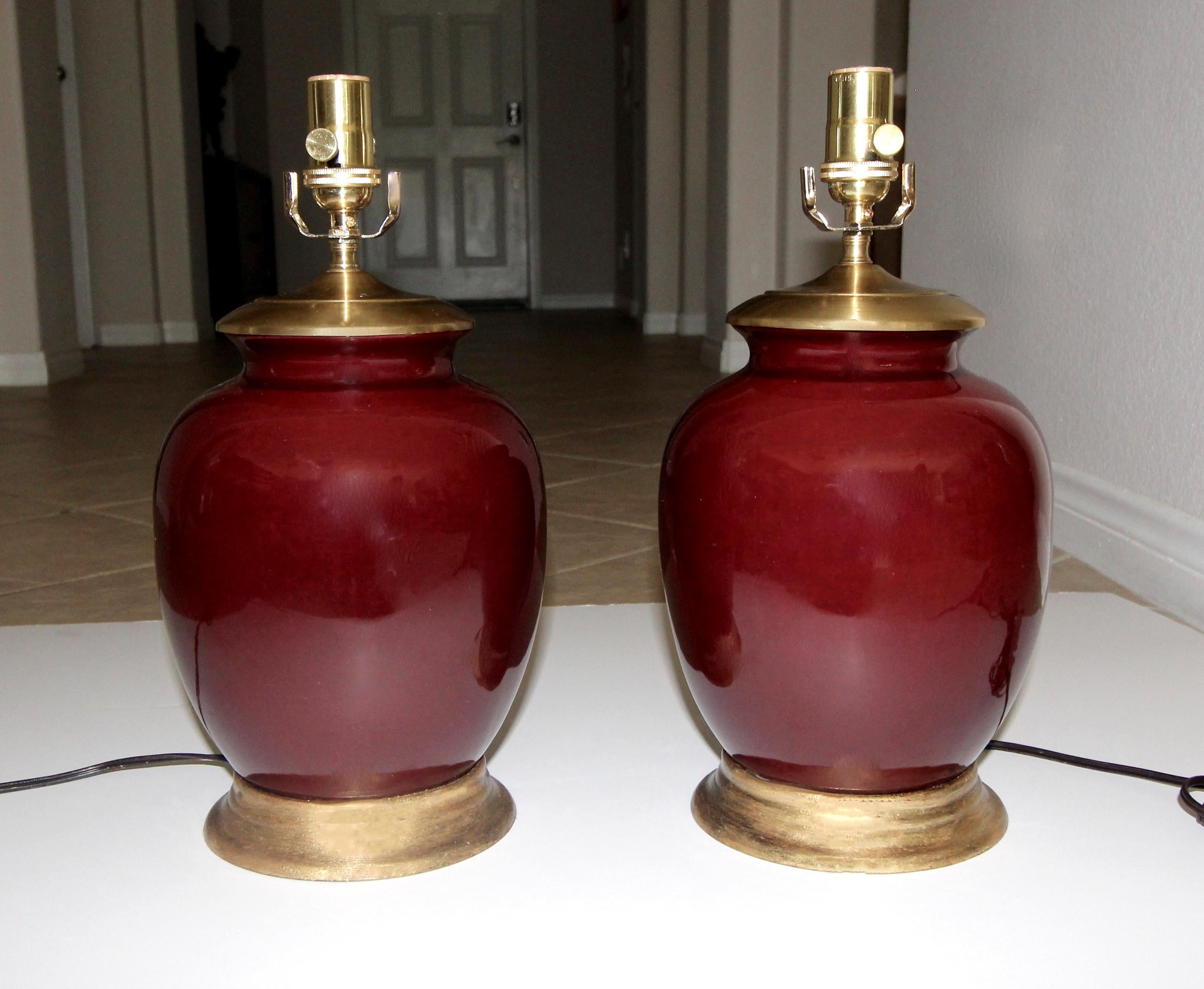Pair of late Asian oxblood porcelain vases mounted on gilt turned wood lamp bases. Rewired with all new fittings and sockets. Smaller scale lamps, overall height top of socket 15