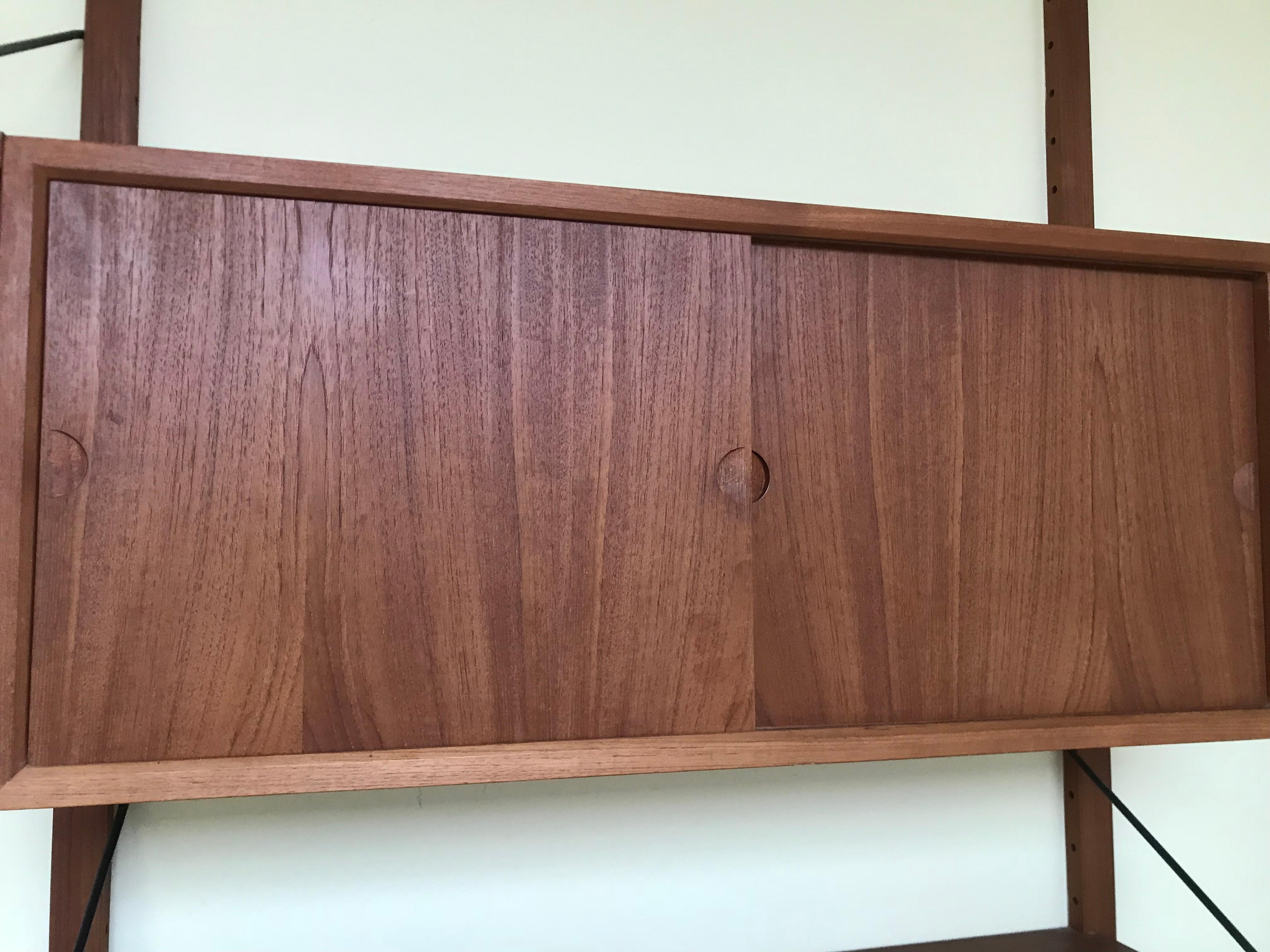 Highly versatile and functional Cado wall unit in teak by Danish designer Poul Cadovius. Wall unit is in very nice vintage condition with light age appropriate wear. Each support rail is 78