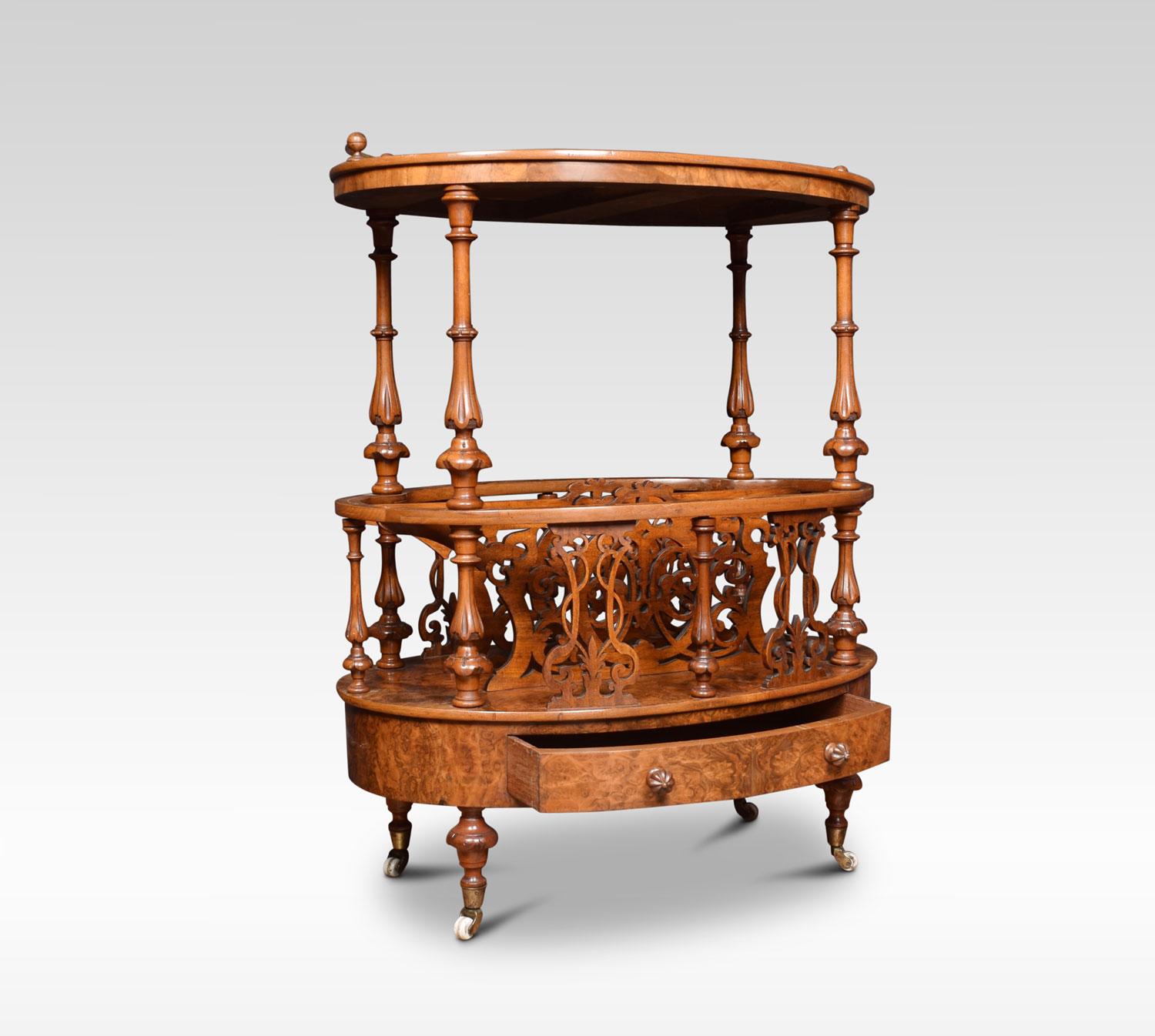 Victorian walnut and inlaid oval Canterbury, the oval top inlaid with boxwood lines and foliate arabesques with low curving brass gallery. Raised on four baluster and lappet-carved supports. The base section wit shaped and scroll fret-pierced