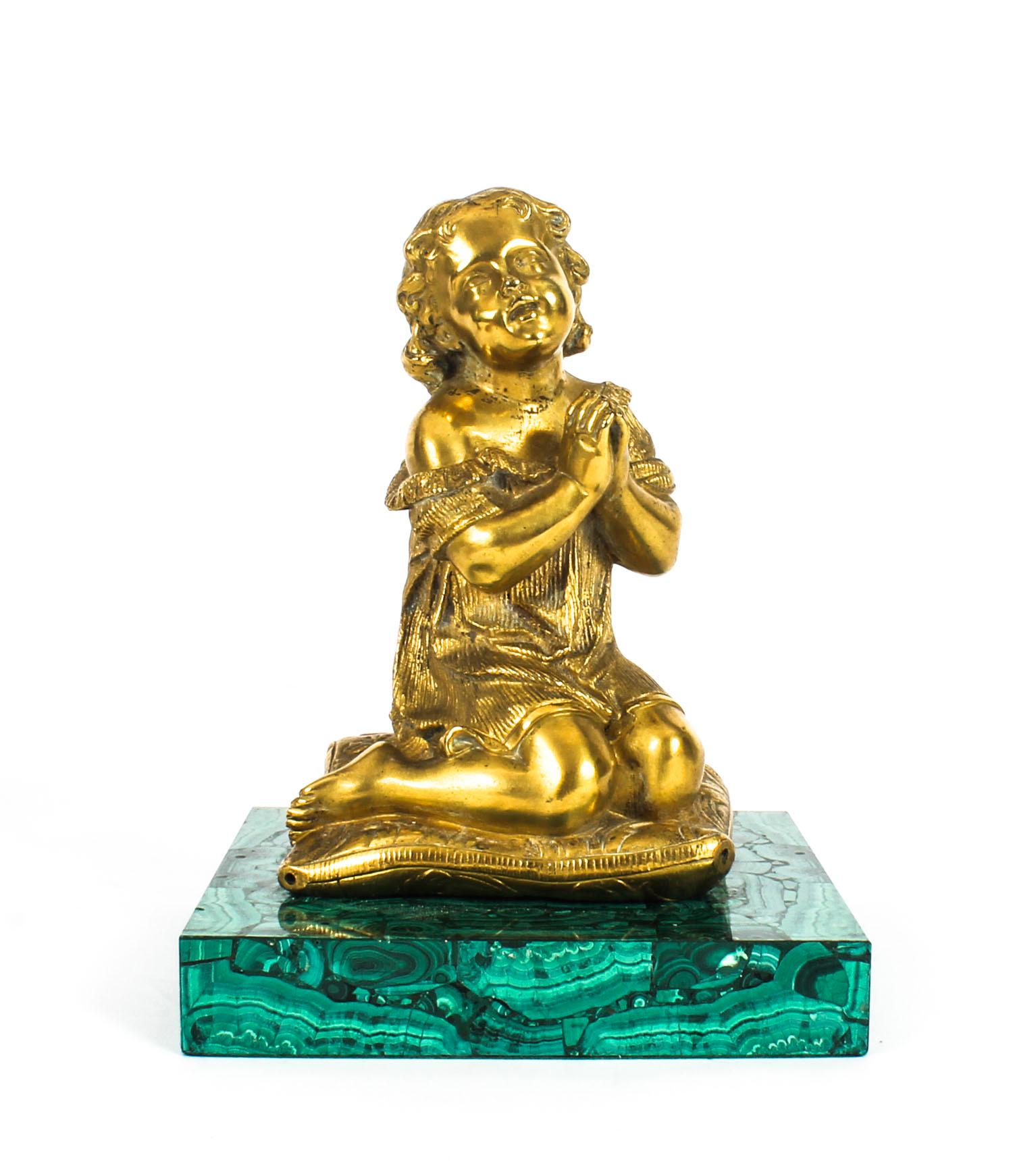 This is a wonderful antique French ormolu and malachite sculpture of a girl, circa 1870 in date.
 
The finely cast ormolu figure of a young girl kneeling in prayer on a cushion sits on an elegant square malachite base.
 
There is no mistaking