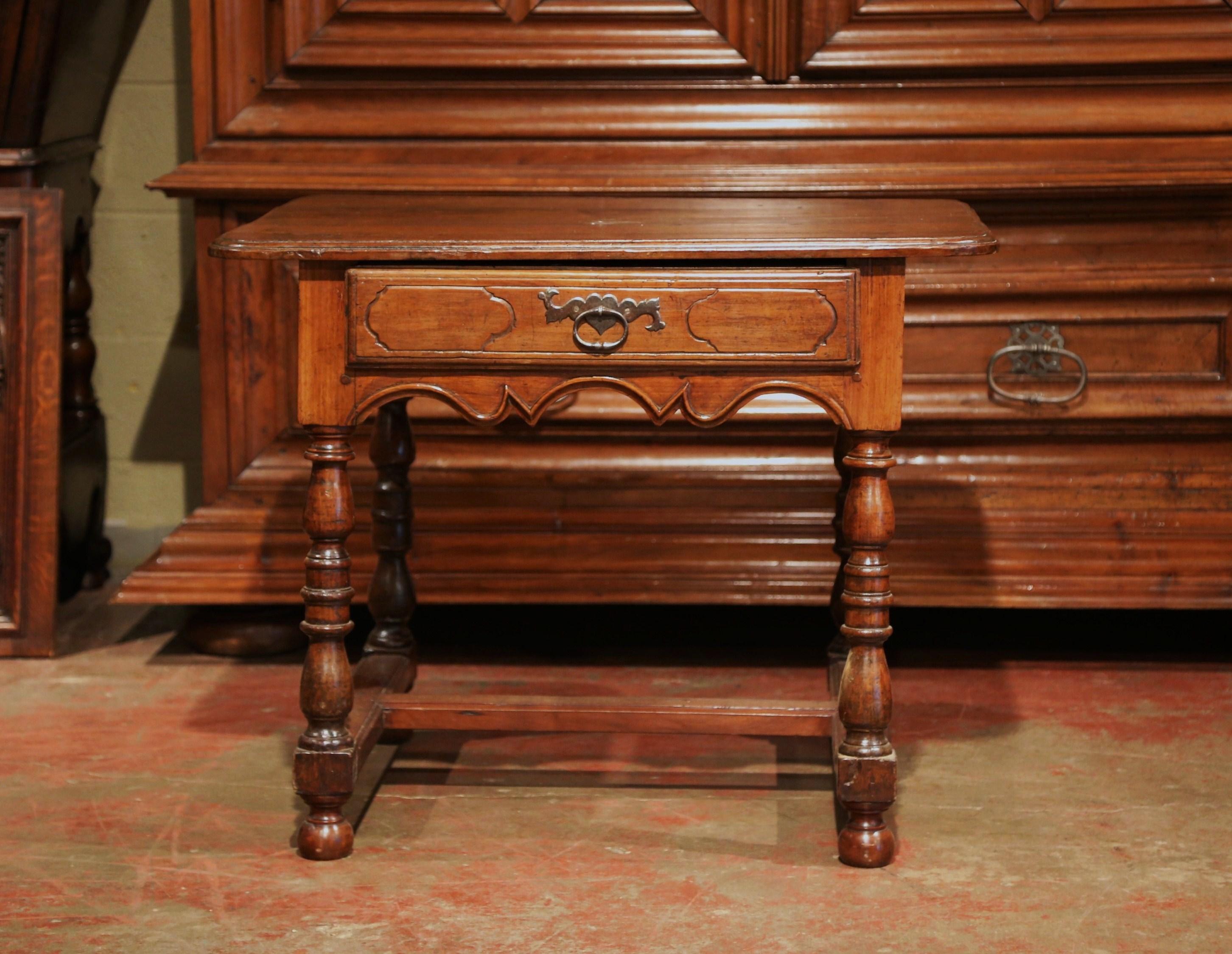 Incorporate extra, functional surface space into your living room with this elegant fruitwood end table. Crafted in the Perigord region of France, circa 1760, the side table features a single drawer across the front embellished with the original