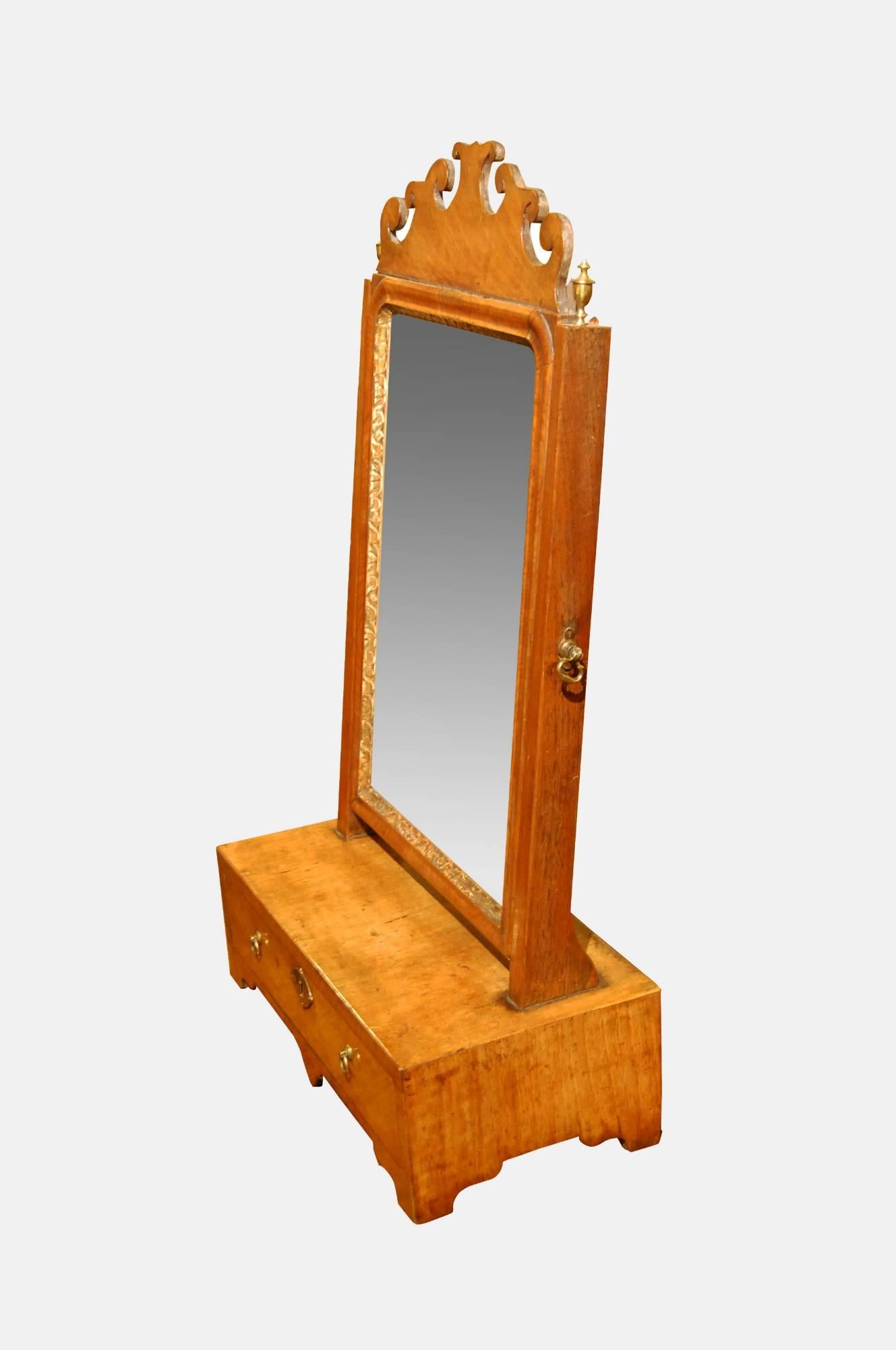 Queen Anne walnut box base mirror.

Crested frame with original plate above a single drawer retaining original brassware and lock,

circa 1710.