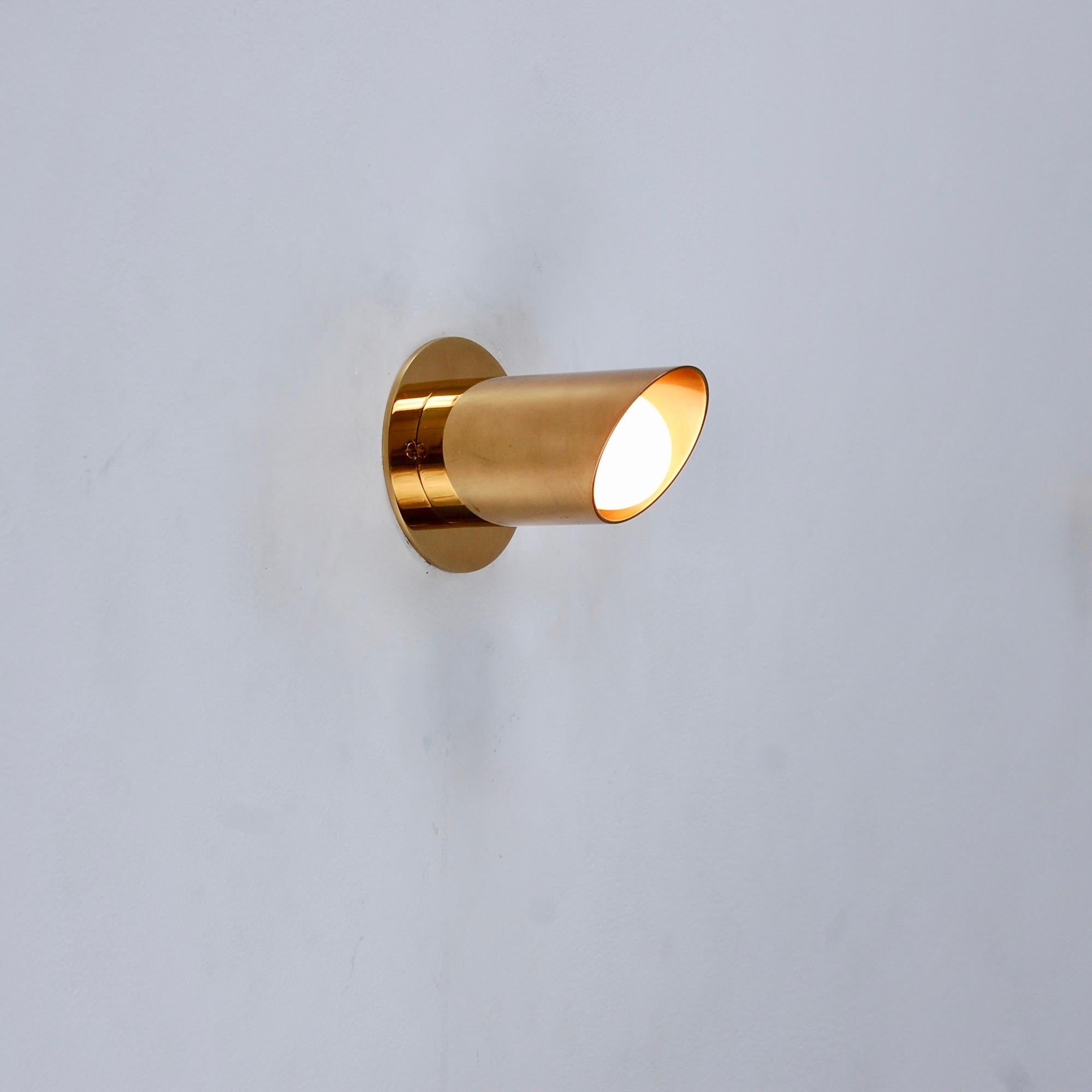 LUpipe classic all brass tailpipe sconce in aged patina brass by Lumfardo Luminiares. Inspired by 1950s Italian midcentury design, this sconce is ideal for vanity mirrors or to illuminate an artwork wall. Can also be used as ceiling mount. Single
