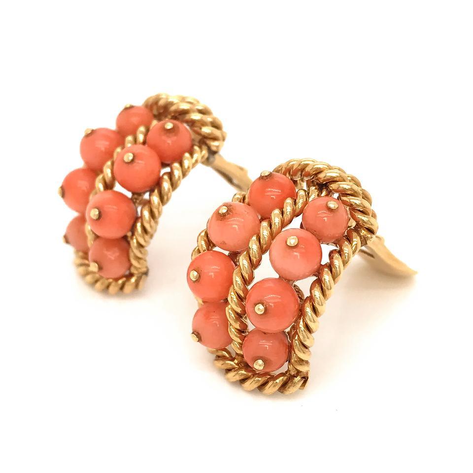 David Webb was one of the most important American jewelry designers, and his pieces are still in demand today. This beautiful pair of earrings is from the 1970's, and features bead corals, accented by the twisted gold rope work characteristic of the