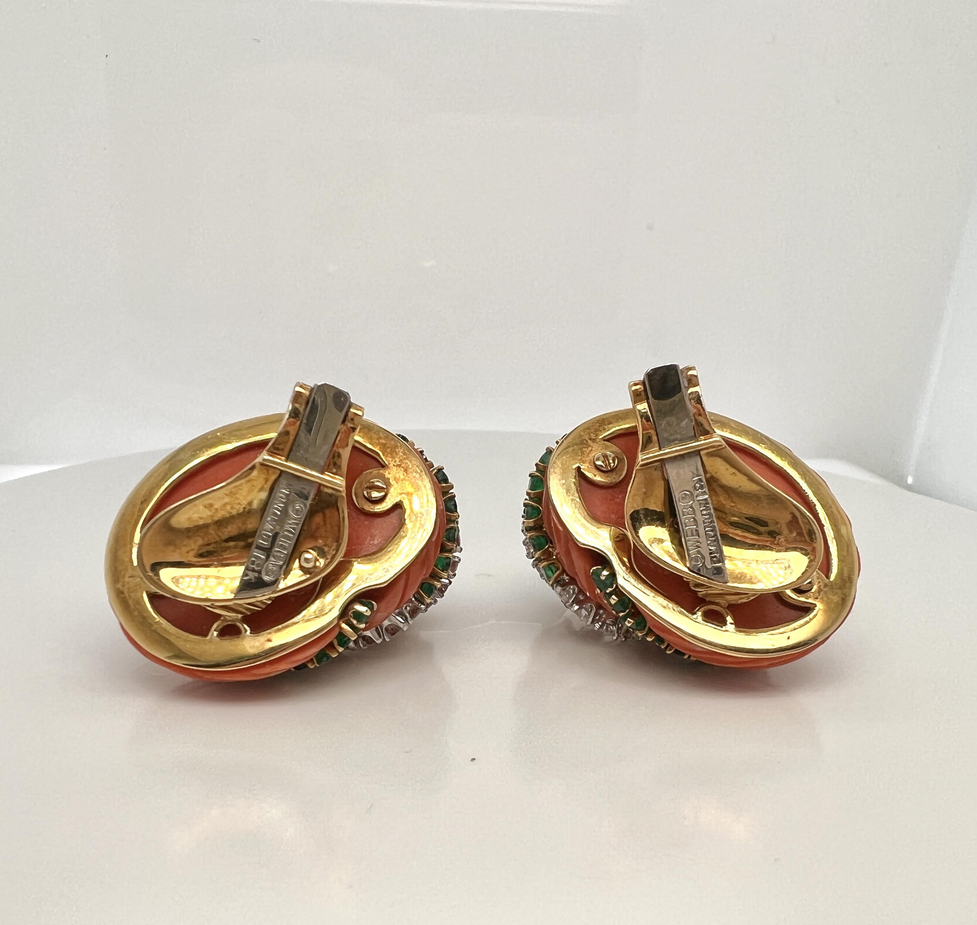 David Webb Platinum, 18K Gold, Coral, Diamond, and Emerald Earclips.

The shell-form earclips of carved coral body featuring spirals of circle-cut emeralds weighing approx. 1.04 tcw. and full-cut diamonds weighing approx. 1.55 tcw., signed WEBB;