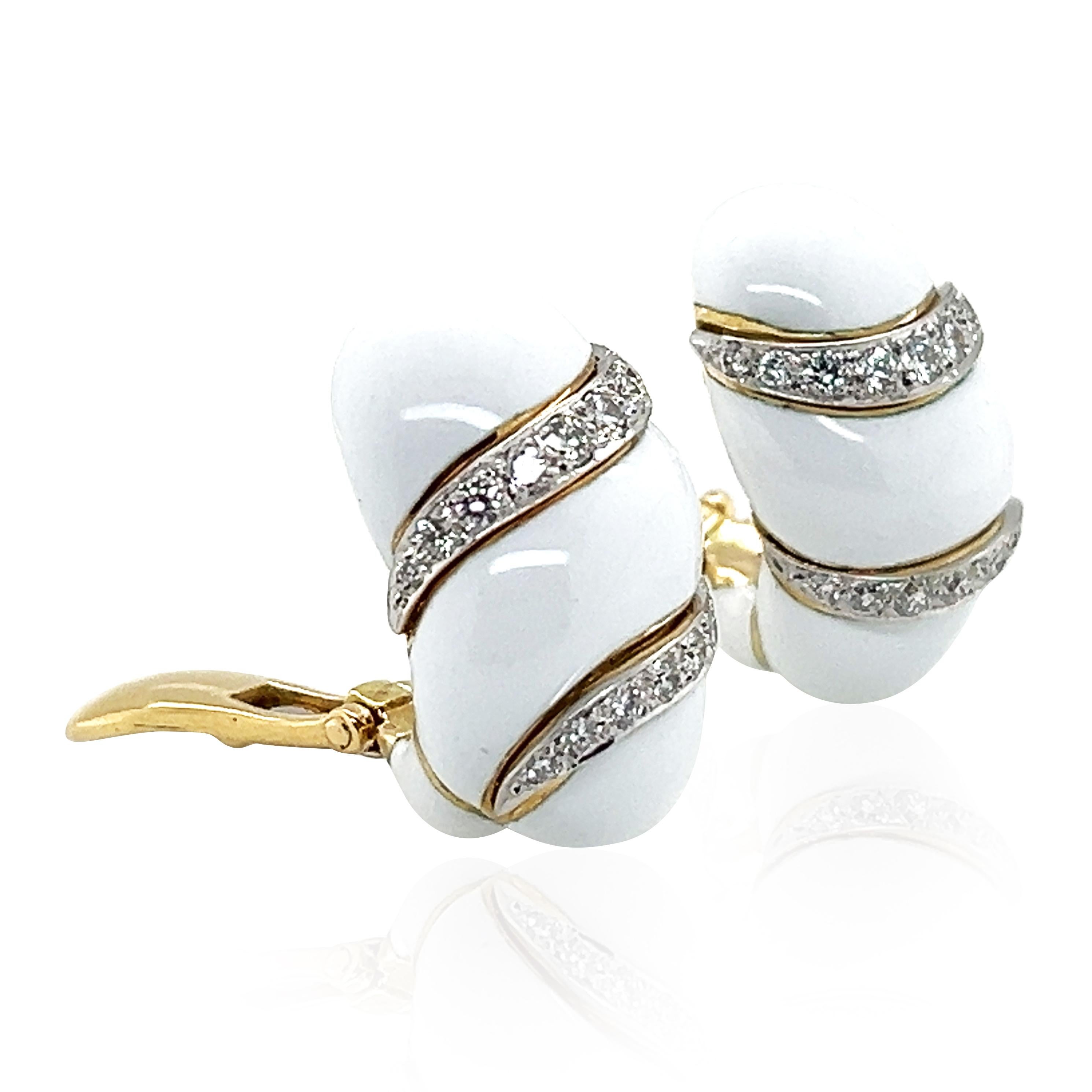 These David Webb clip-on earrings showcase the house’s signature elegance with bold white enamel and shimmering diamond wave lines. Crafted from 18K gold and platinum, they feature approximately 0.92 carats of brilliant-cut diamonds. The sculptural