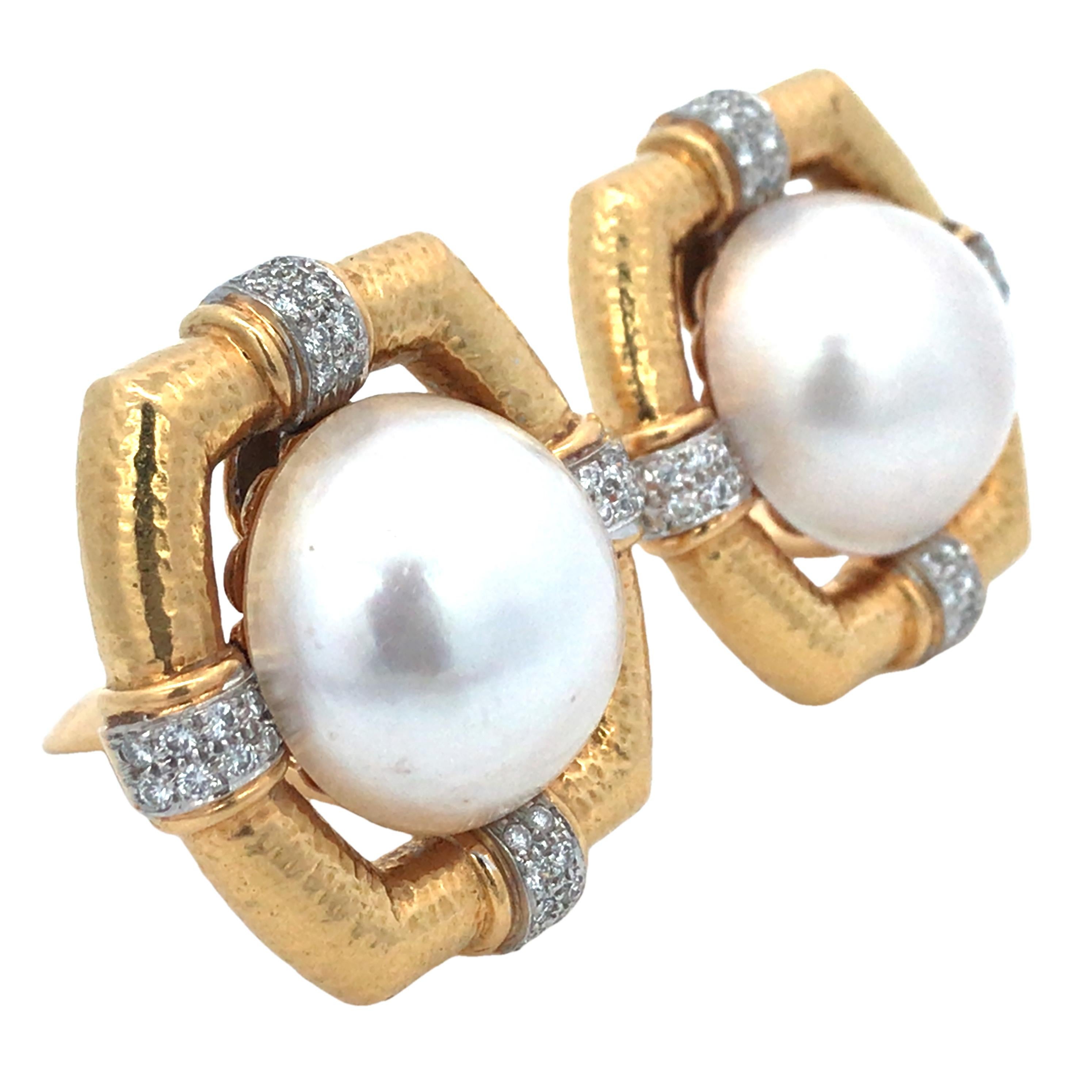 Questi orecchini David Webb emanano un fascino audace e sofisticato, unendo l'eleganza classica al lusso moderno. Le perle Mabe da 18 mm, con il loro splendore, sono incorniciate da oro 18 carati e platino. Impreziositi da circa 0,32 carati di