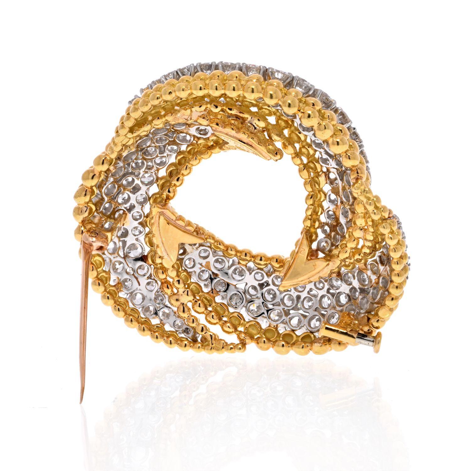 Mounted with 123 round brilliant cut diamonds this brooch is sure to be the center of attention. Designed and crafted by David Webb in Platinum & 18K Yellow Gold mounted with 15 Carats of diamonds in a swirl knot motif. 
About 1 inch wide. 