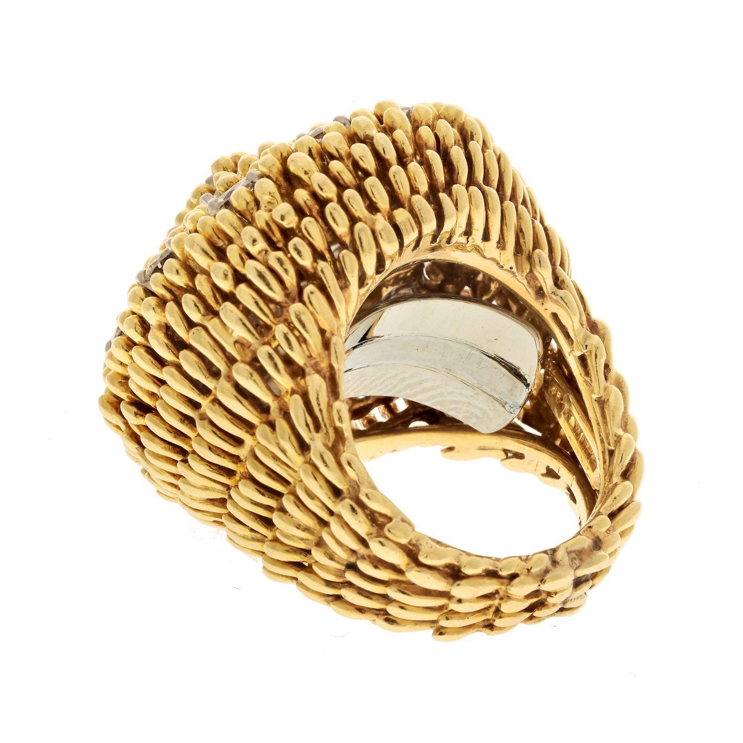 The David Webb Platinum & 18K Yellow Gold 1960s Diamond Textured Cocktail Ring is a stunning piece of jewelry that showcases the brand's iconic design and exceptional craftsmanship. This cocktail ring features a wide, spready top that is adorned