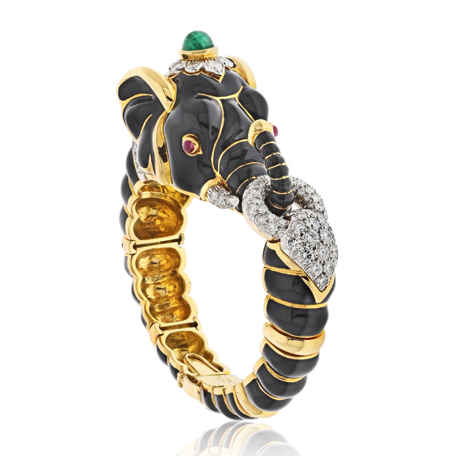 The David Webb 18k yellow gold black enamel diamond, ruby, and green emerald elephant bracelet from the Kingdom Collection is a truly exceptional piece of jewelry that exudes luxury and sophistication. The bracelet features a striking design with a