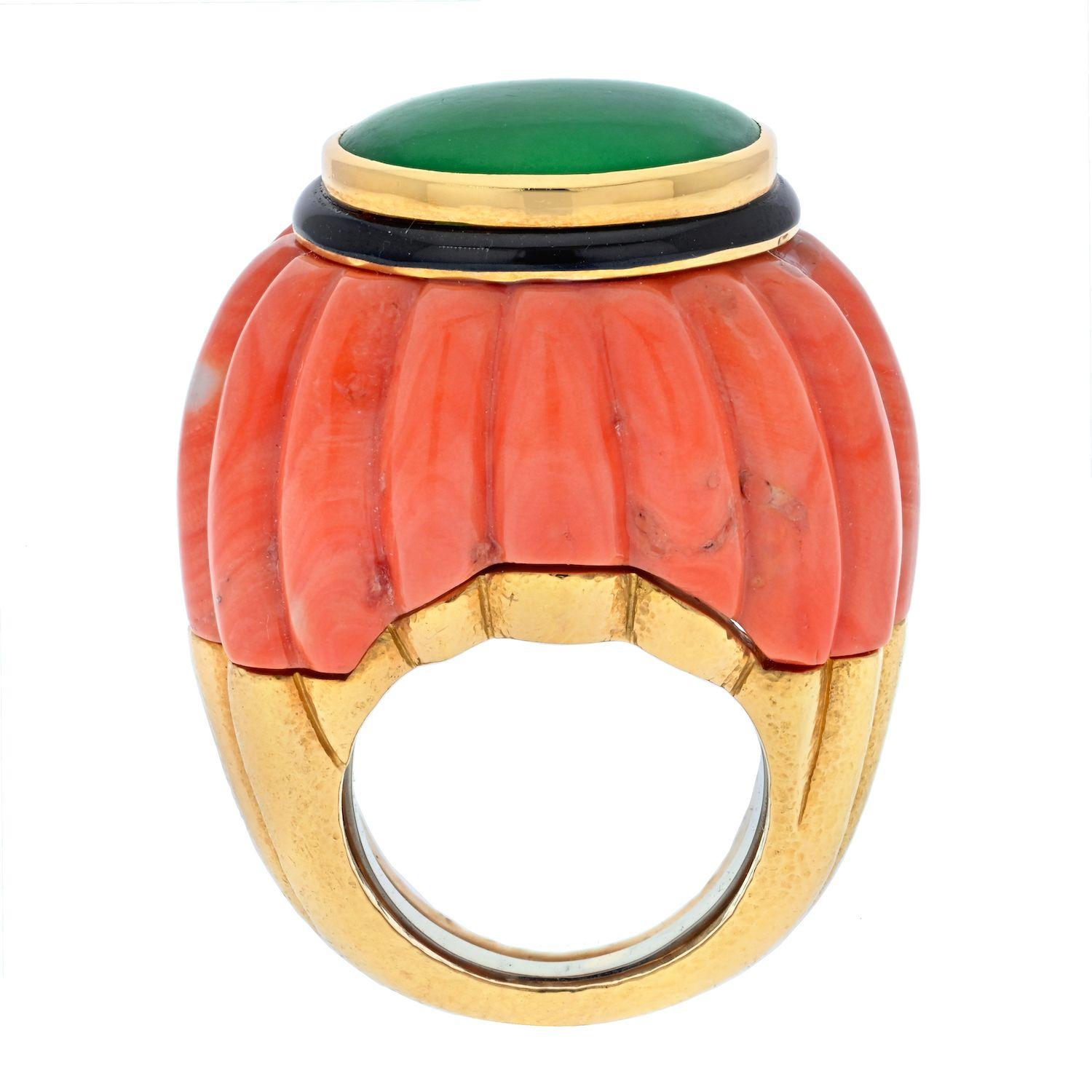 18K yellow gold jade and coral ring by David Webb. Features an oval polished piece of jade in the center. Black enamel highlights the coral and jade. The base of the ring is a single piece of carved coral. Ring is currently a size 6 with a butterfly