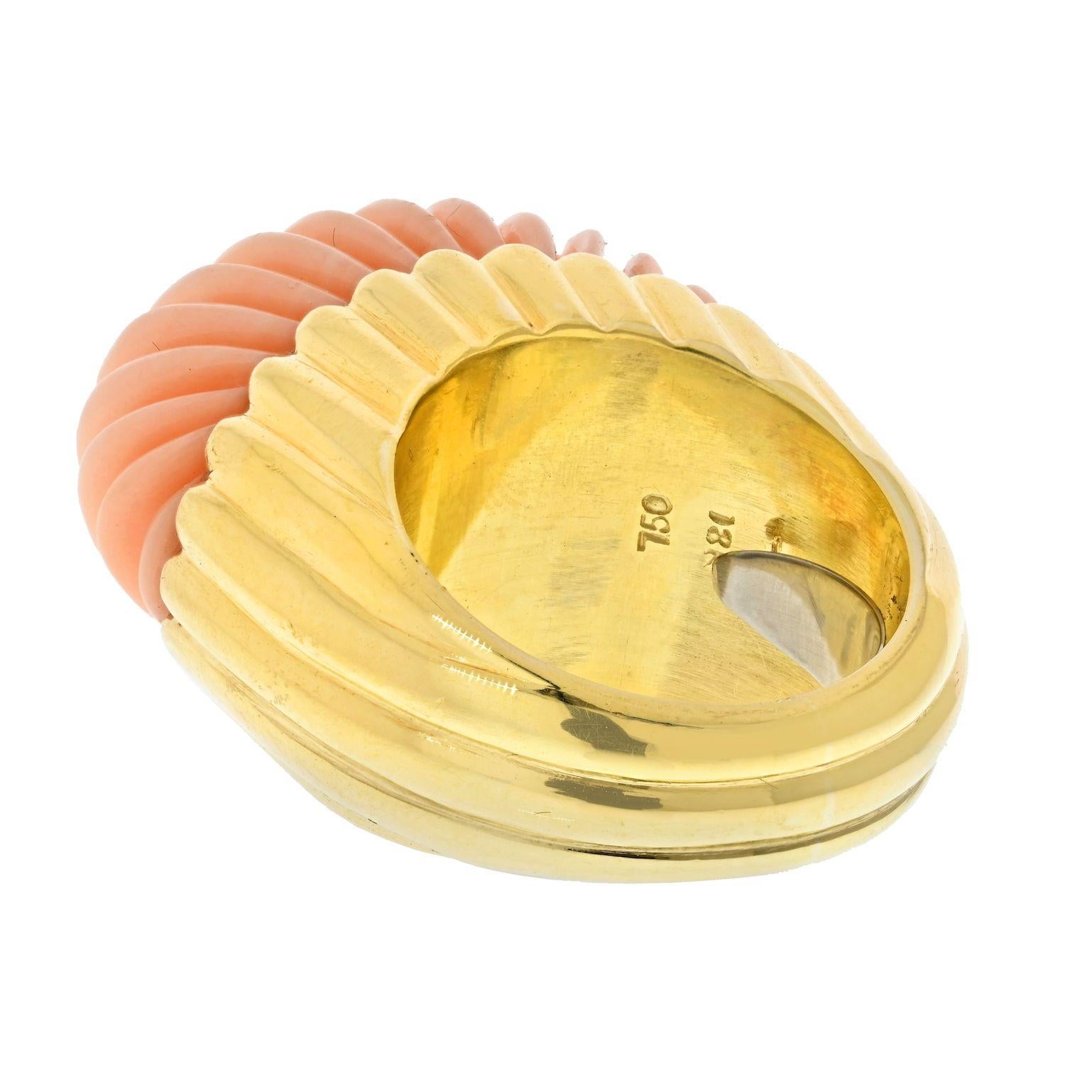 This fabulous 1970's right hand/cocktail ring designed by David Webb. This beautiful ring features a carved cabochon cut coral in 18k yellow gold.  The carved piece of coral features a gorgeous ribbed appearance that provides a wonderful contrast