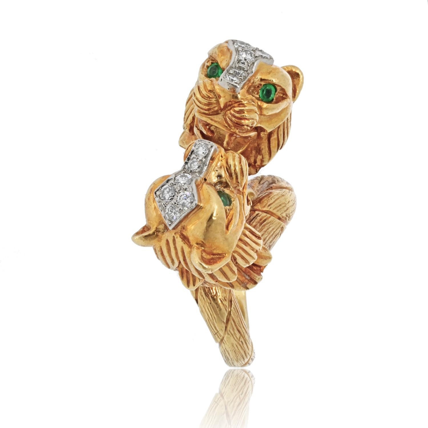 Step into the world of timeless elegance with this vintage David Webb 18k yellow gold double head lion ring. Featuring two majestic lions facing each other, this ring exudes strength and sophistication. The lions are adorned with mesmerizing green