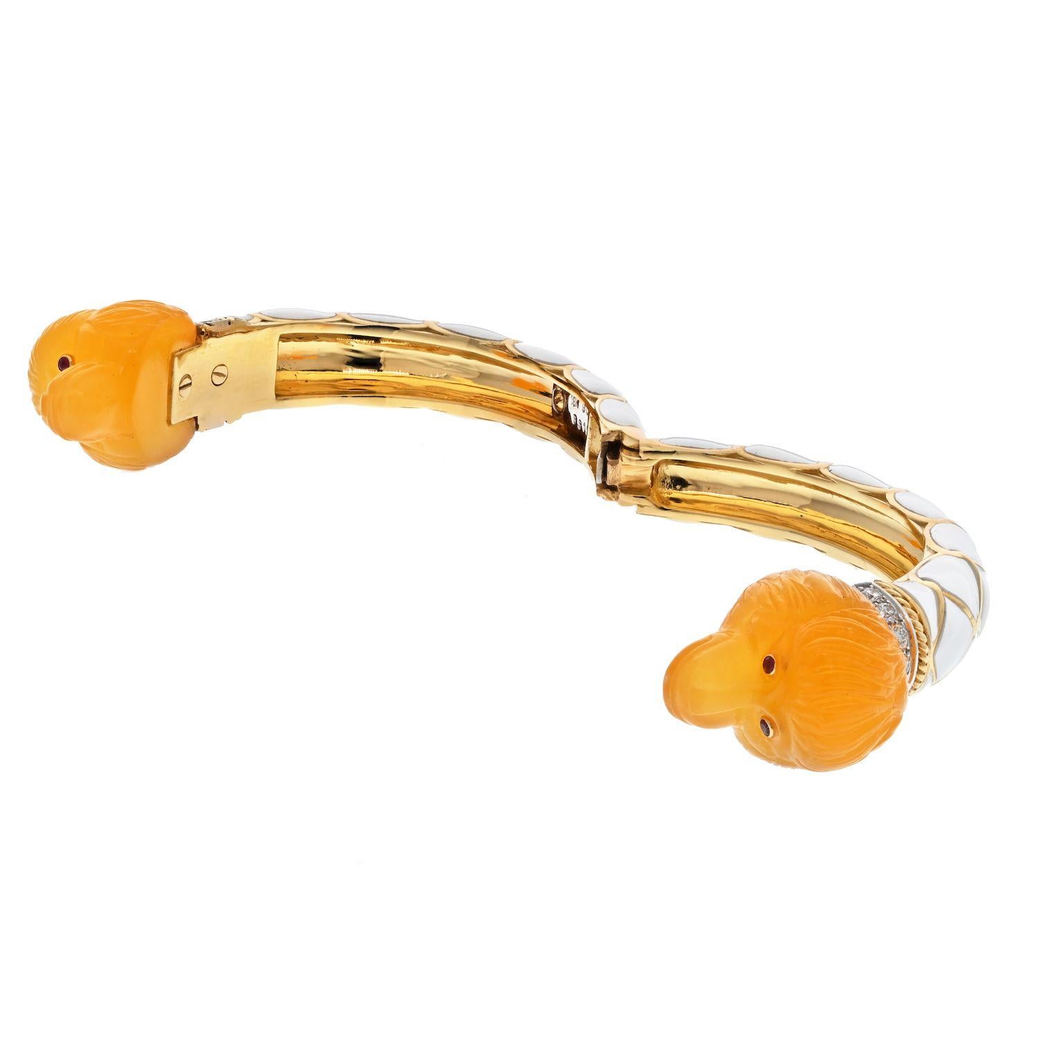 Vous aimerez ce bracelet David Webb pour son design unique et exquis. L'or blanc 18kt est magnifique et s'entrecroise de manière complexe avec l'émail. Les deux têtes de singe sculptées dans la cornaline sont particulièrement captivantes avec leurs